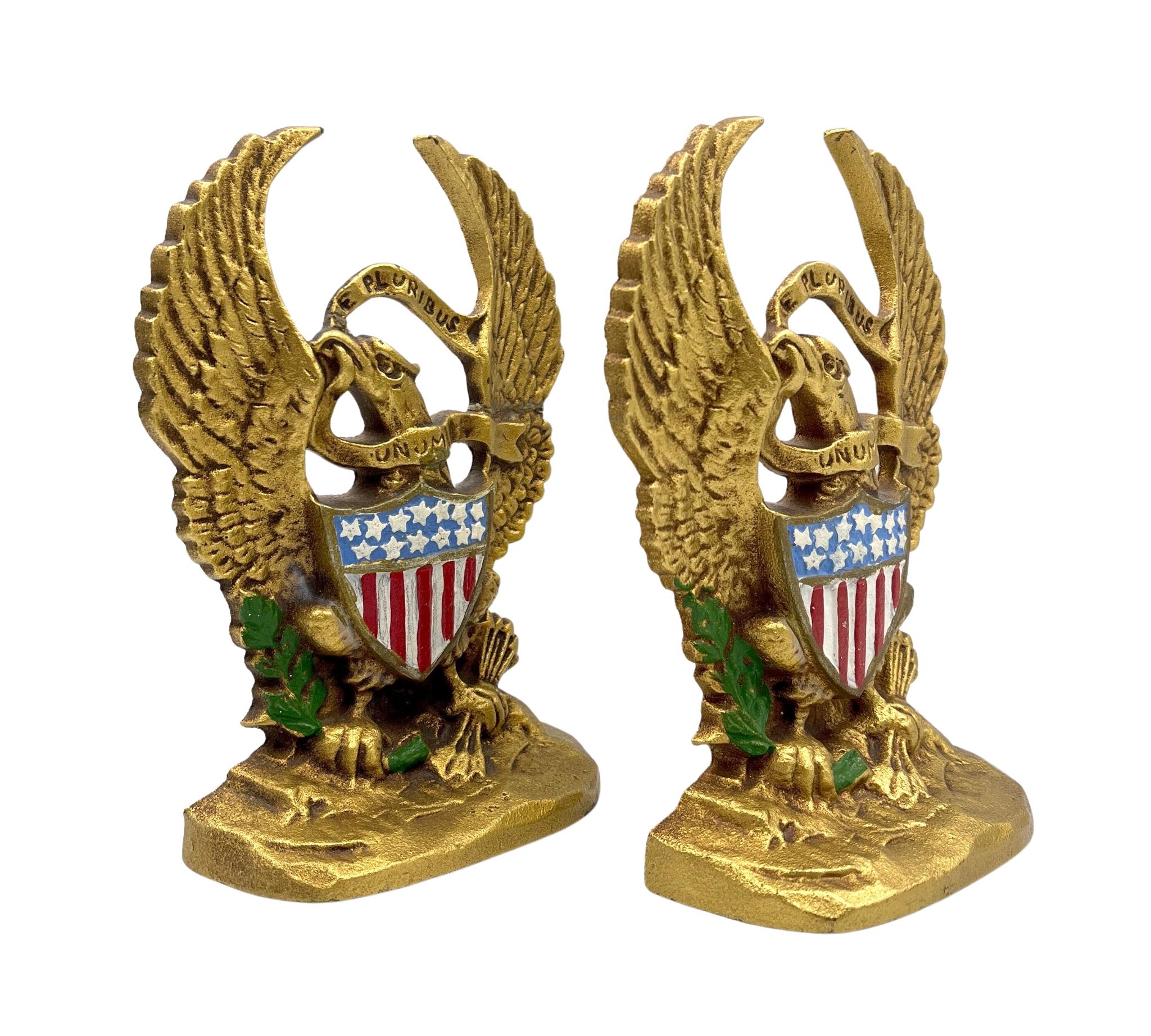 Presented is a vintage set of brass bookends from the early 20th century featuring a spreadwing eagle. Fashioned after the Great Seal, the eagle holds a laurel branch and bundle of arrows clutched in its talons. The eagle has a Union shield across