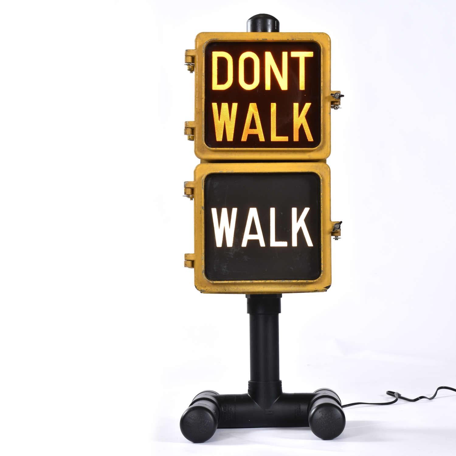 Vintage Eagle Signal walk traffic signal. This authentic “walk” / “don’t walk” traffic signal has been refurbished to be used as a table lamp. Our restoration team re-wired the lamp with an on/off toggle switch on the power cord. Both the “Walk” and