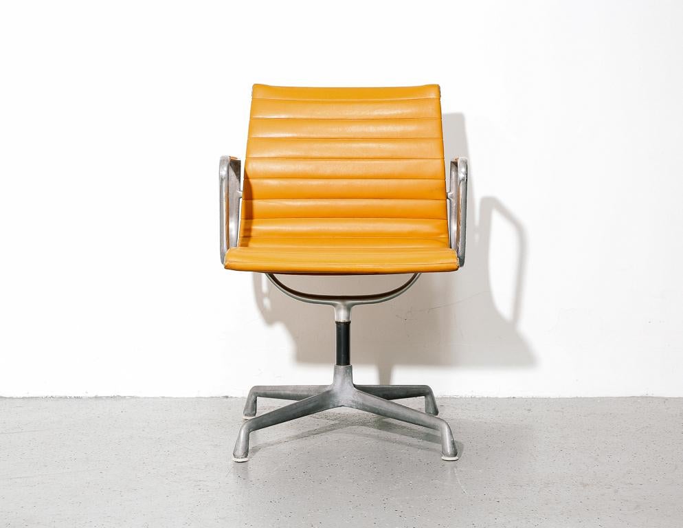 Eames for Herman Miller management chair. Orange naugahyde upholstery on aluminum frame and base. Stamped by the manufacturer on underside of seat frame. Three available.