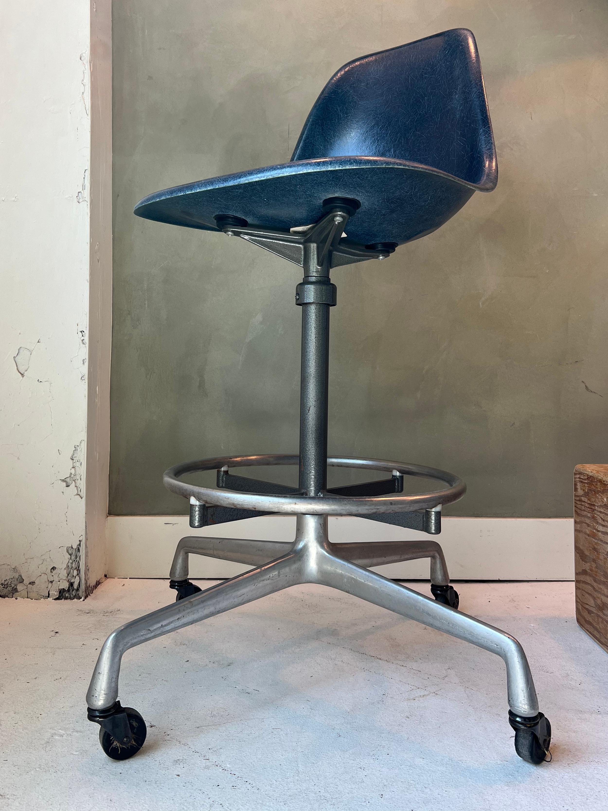 Vintage Eames drafting stool with navy blue fiberglass shell chair. In amazing condition for the age; the color is deep and saturated and the steel shows wear consistent with age. Swivels and adjusts easily. 
