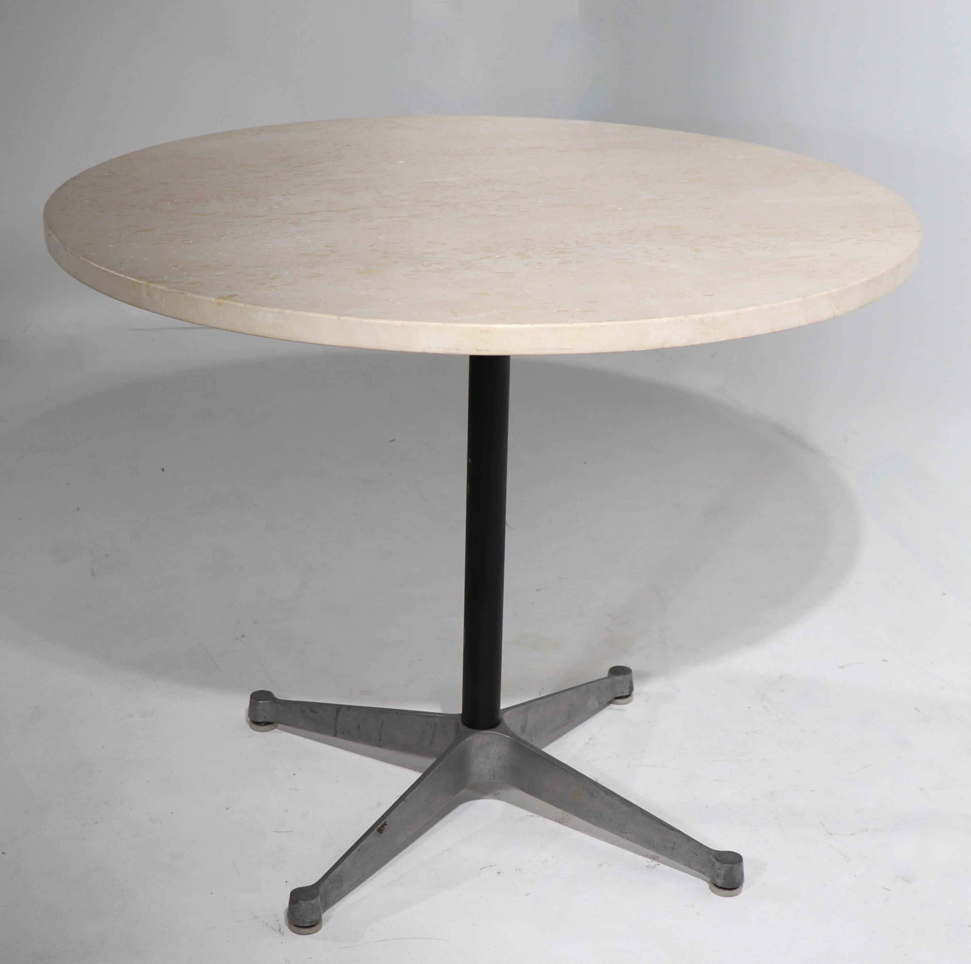 Nice vintage Eames table with the classic contract base. This example has a thick ( 1 in. ) travertine marble top, we believe the top is a later addition, but it works well and looks great. Tye base retains its original Xerox foil ID table. The