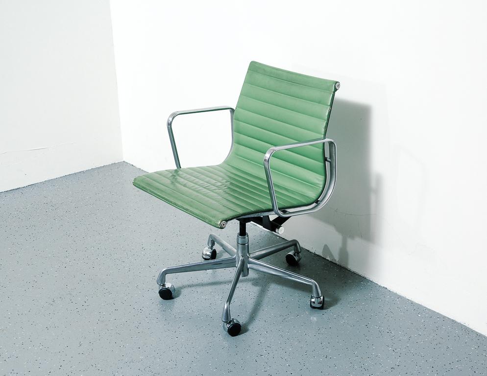 Eames for Herman Miller 'management' chair. Green leather upholstery on aluminum frame. 5-star aluminum base on casters.