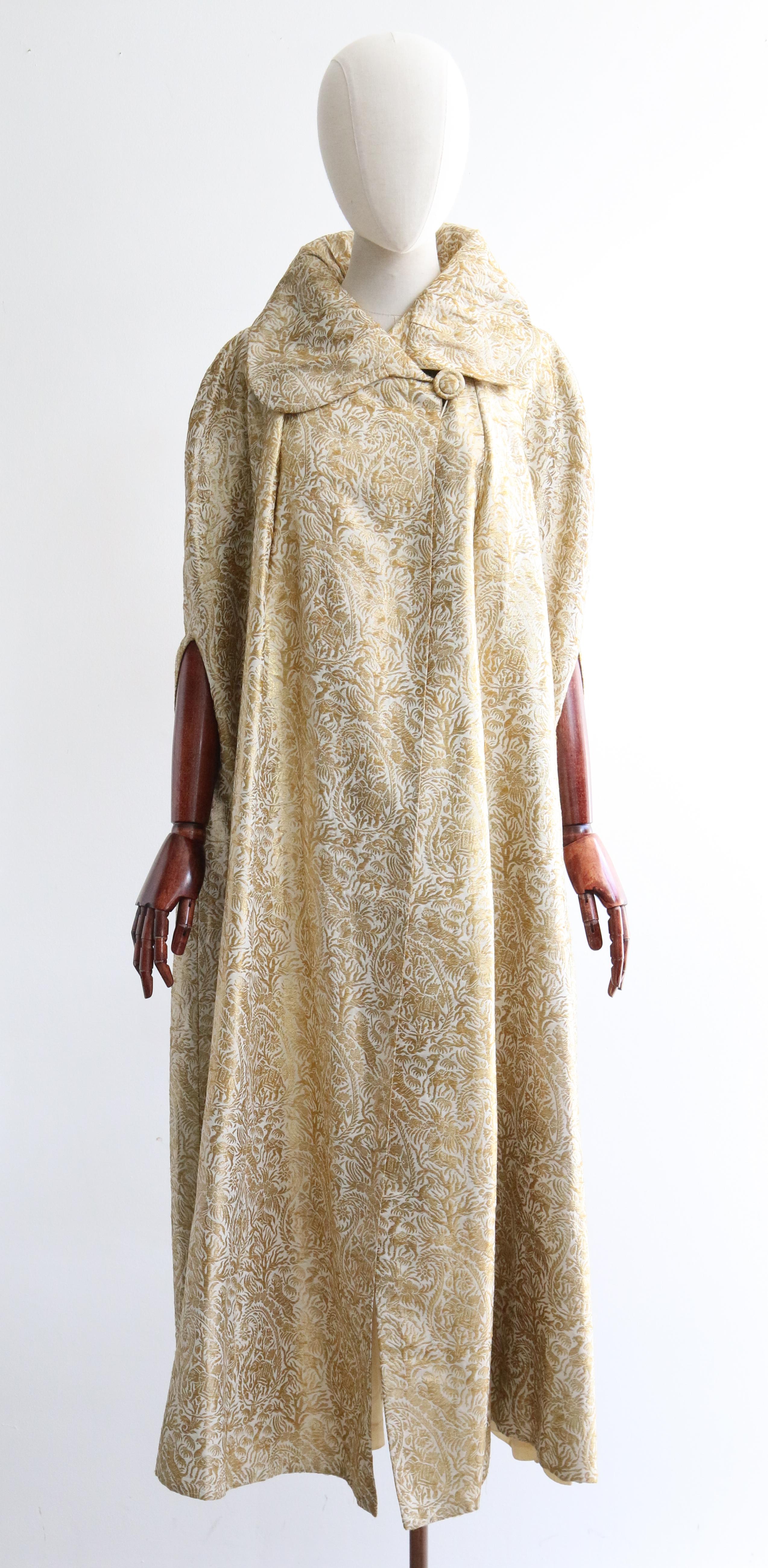 A rare piece to behold and never again find, this original early 1930's cream silk and gold lamé evening cape, rendered in a decadent paisley and animal pattern, is the perfect statement piece for your evening wardrobe.

The wonderful wide rounded