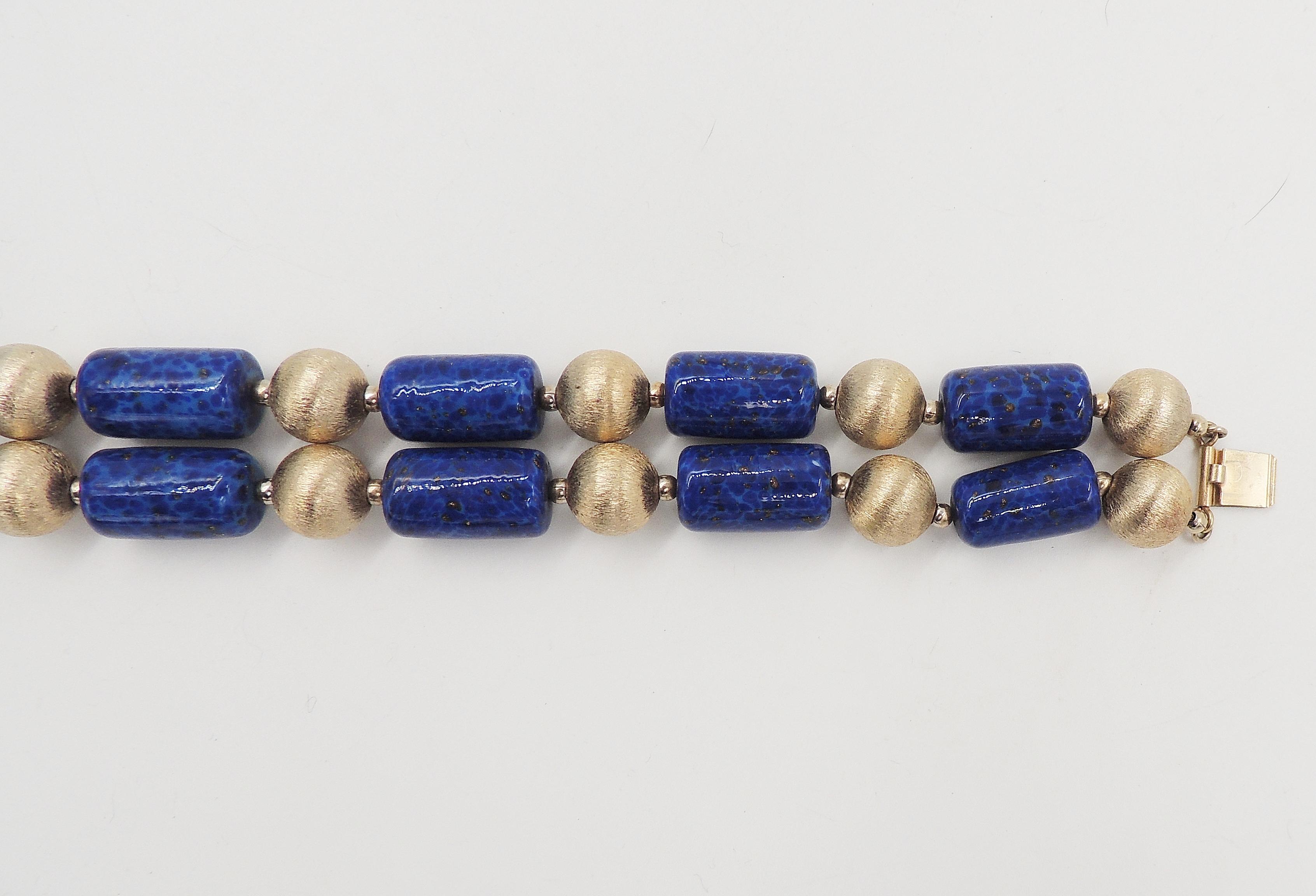 Early 1950s goldtone florentine finish beads and faux-lapis glass beads bracelet with decorative flower box clasp. Marked 