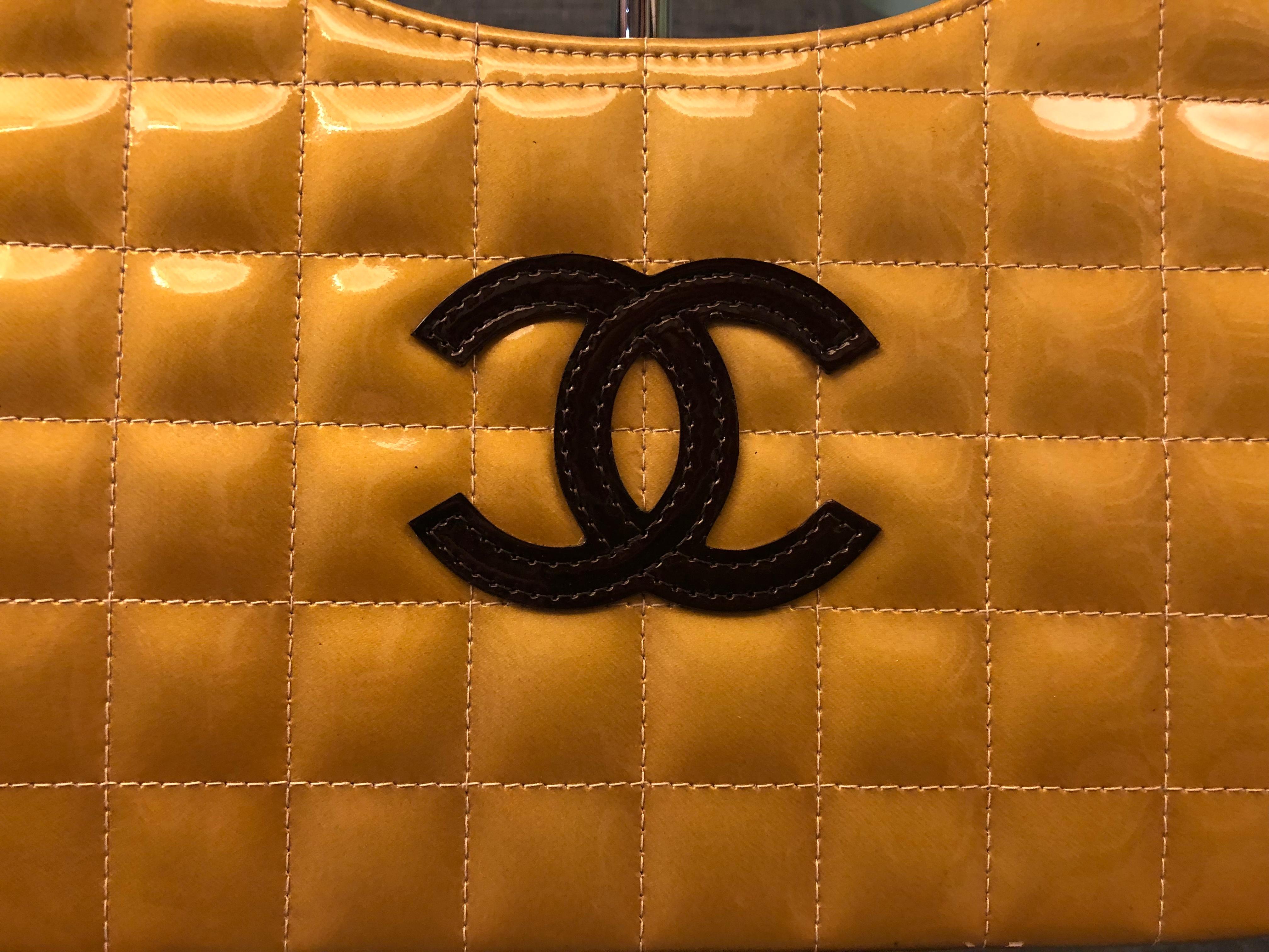 - Chanel yellow patent leather with “CC” handbag. 

- Kiss lock closure. 

- Full package with card, sticker and booklet 

- Brown silk interior with open pocket. 

- Length: 28cm. Height: 20cm. Width: 9cm. Handle Drop: 20cm. 
