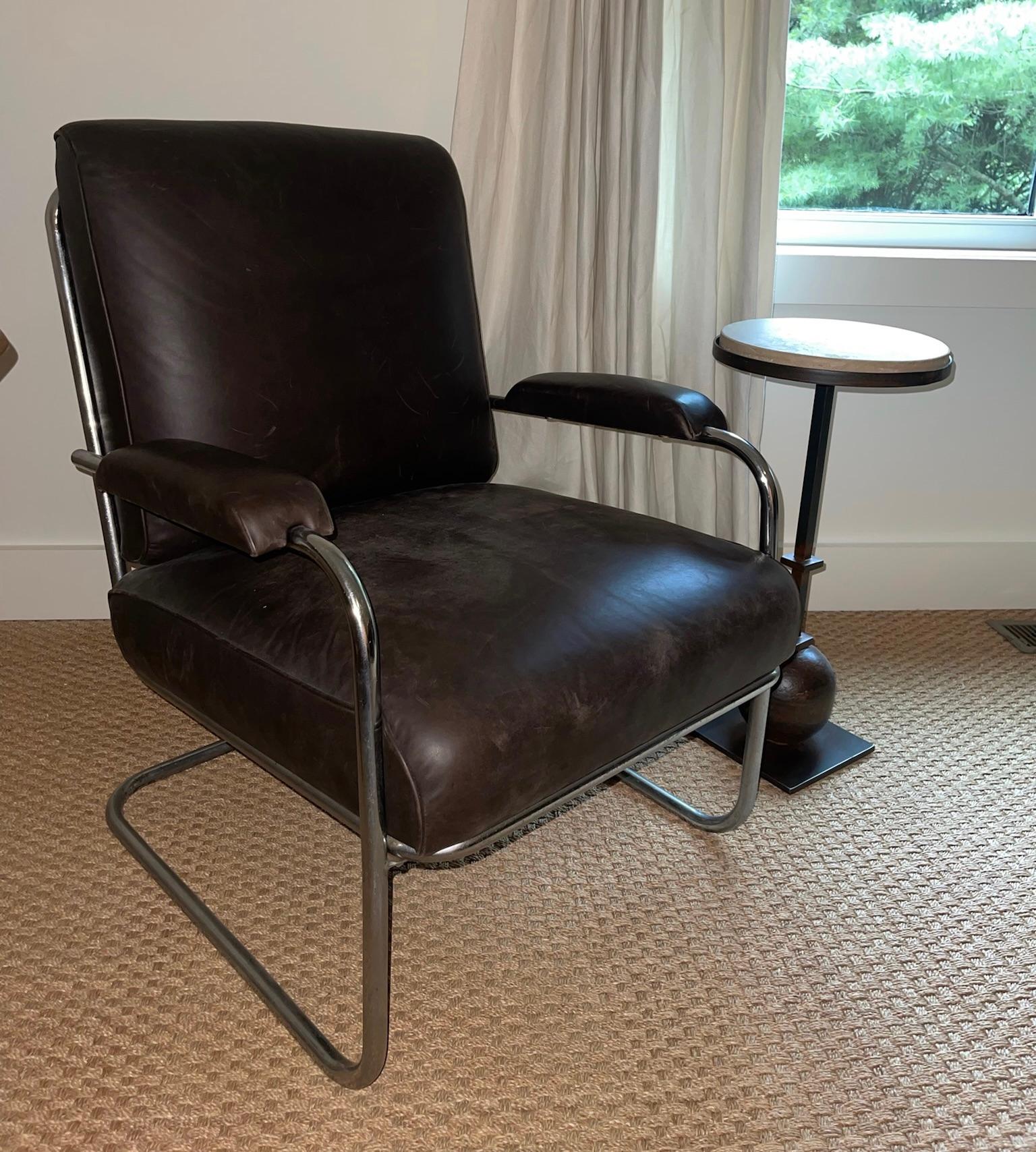 Chaise vintage composée d'une base tubulaire chromée et d'un revêtement en cuir brun foncé.