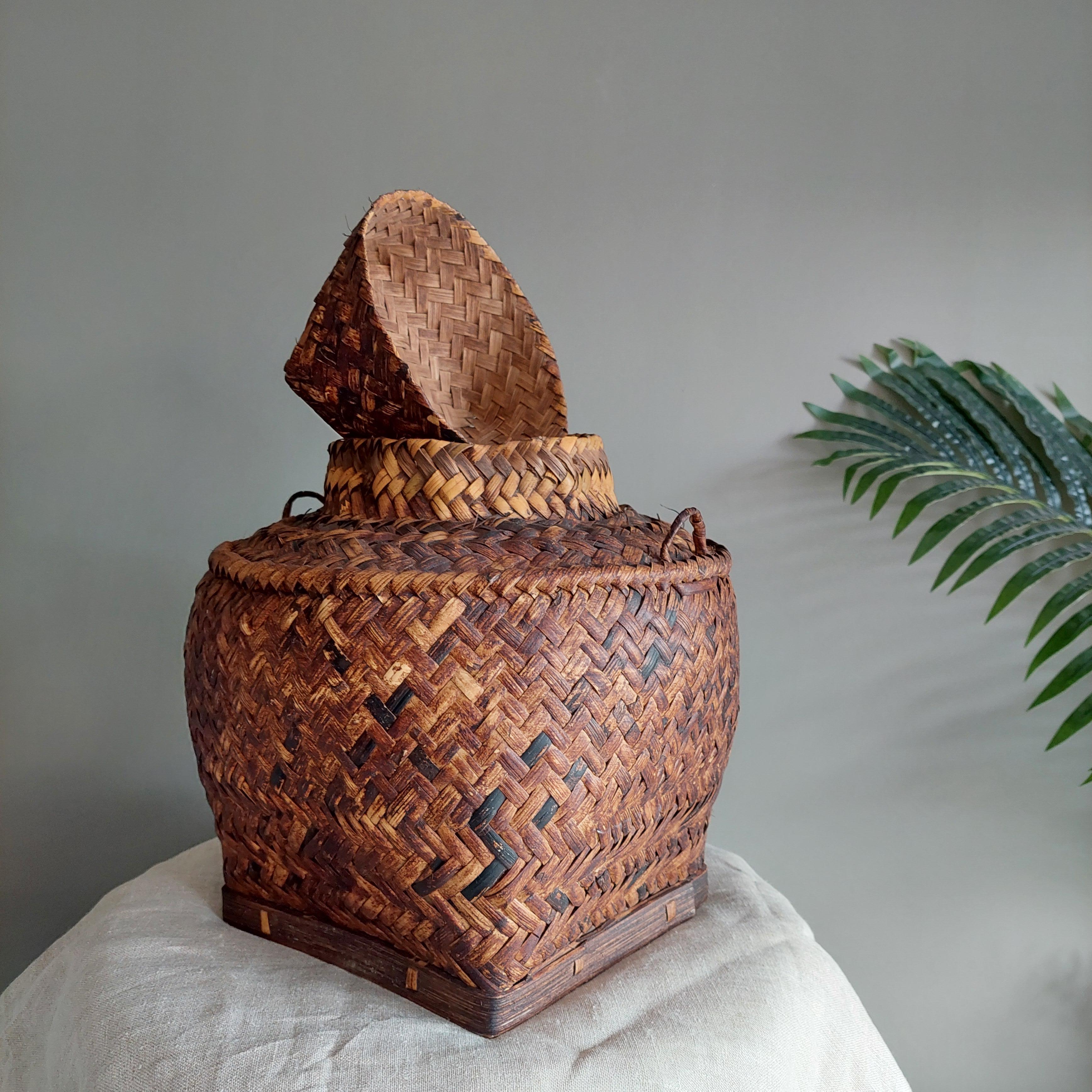 Asiatischer Vintage-Korb mit Deckel.
Schöner Rattankorb mit Fischgrätenmuster.

Dieser wunderschöne, mittelgroße handgeflochtene Reiskorb, der wahrscheinlich vom Stamm der Tagbanwa in Palawan auf den Philippinen stammt, hat eine attraktive Form und