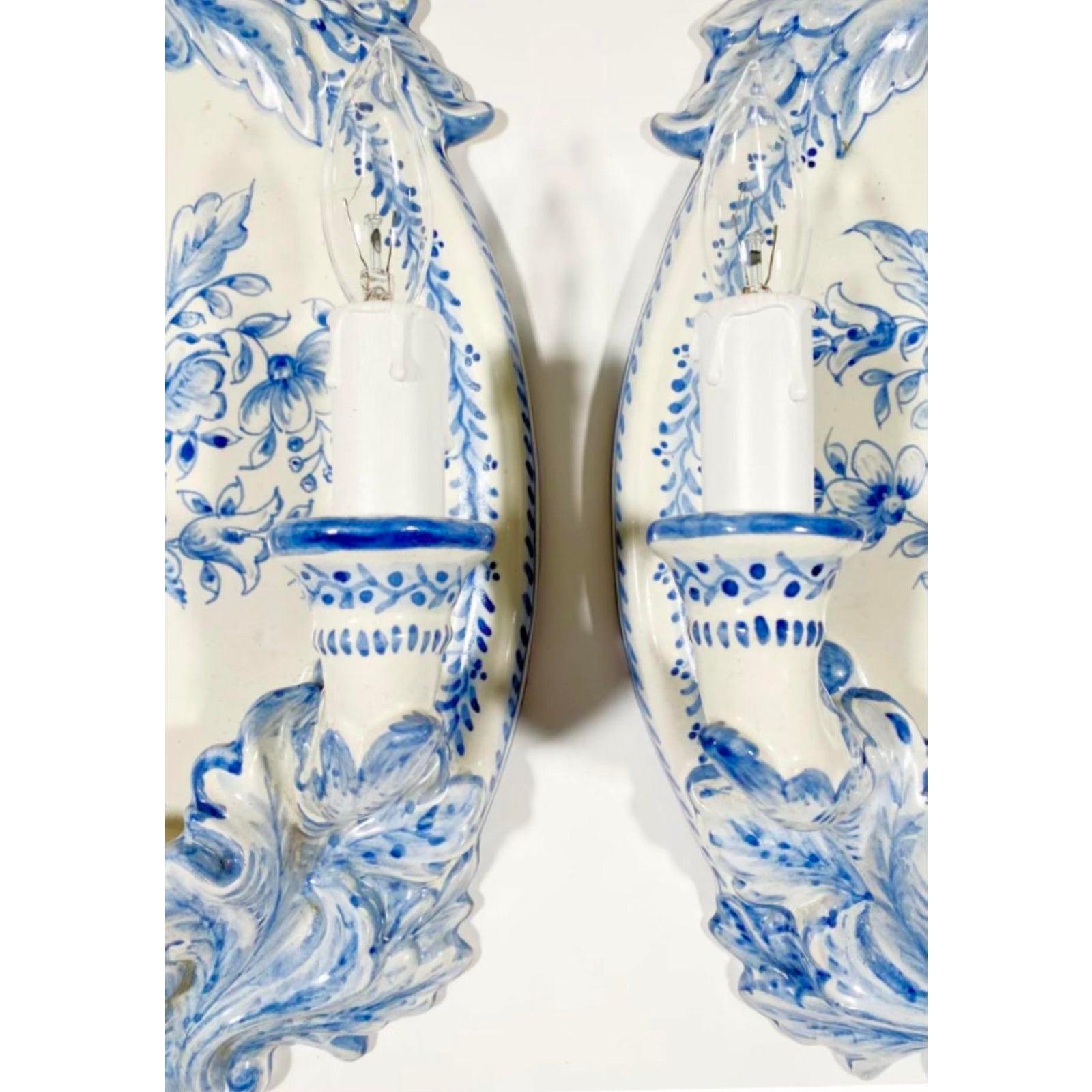 A gorgeous pair of vintage Italian ceramic sconces in white and blue. The floral details are hand painted. Acquired at a Palm Beach estate.