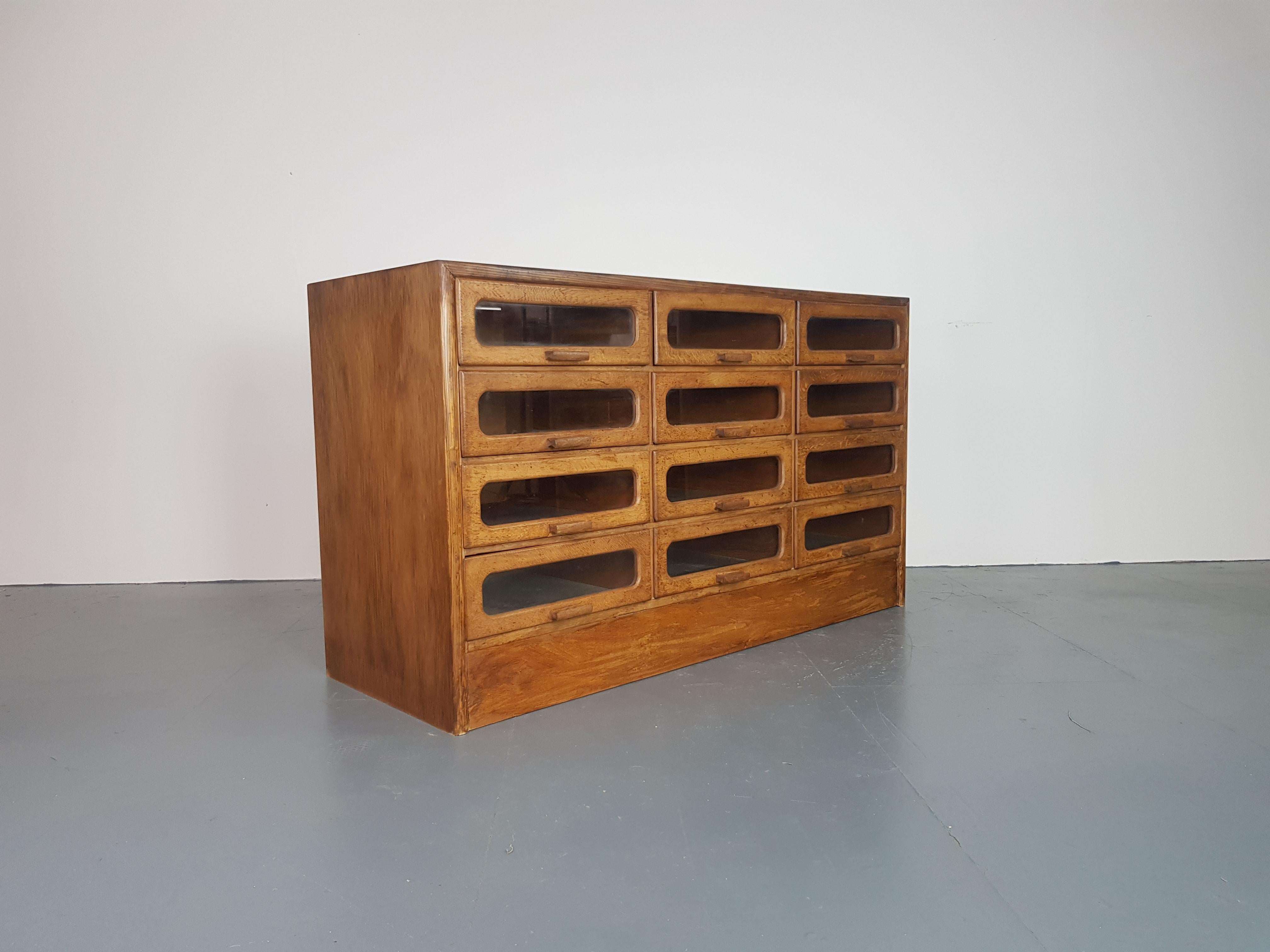 Lovely 12-drawer haberdashery shop cabinet from the first half of the last century. 

It has 12 glass fronted drawers all with original wooden handles.

Approximate dimensions:

Width 138cm

Depth 51cm

Height 80cm

Drawers 40 W cm x 12