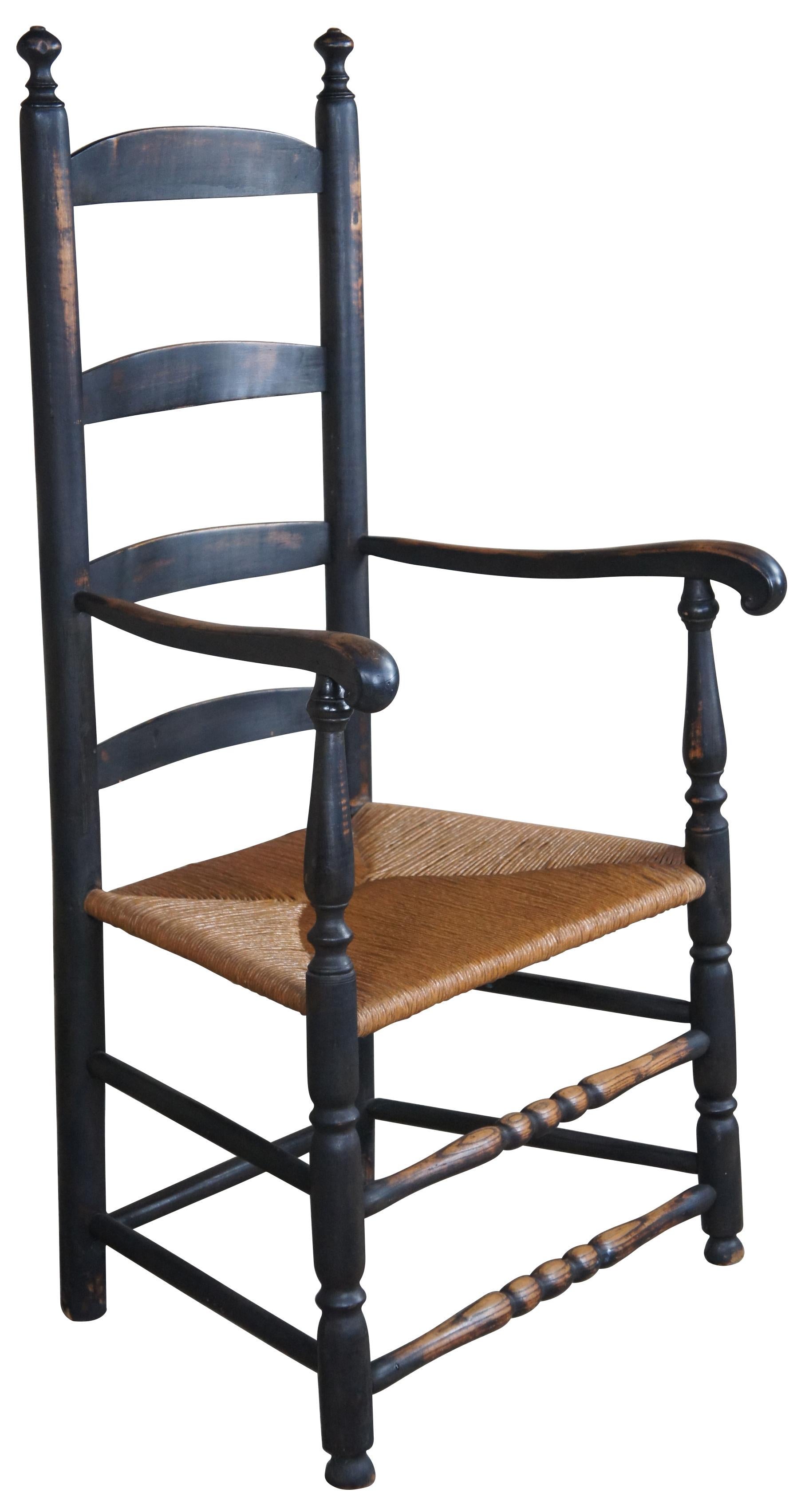 Vintage Early American style shaker ladderback chair. Made from oak with black painted finish, naturally distressed allowing the oak to show through in spots. Features a ladderback design and scrolled arms.
 