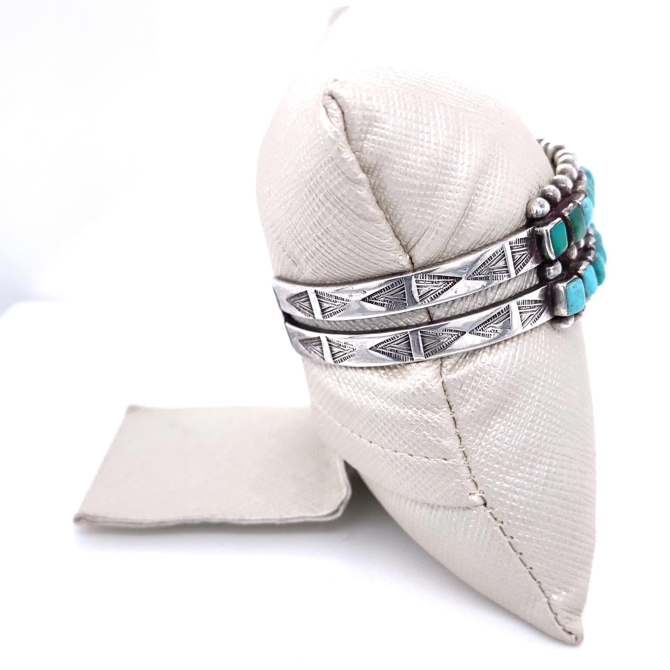 Delightful early, circa 1930s, Zuni cuff bracelet featuring two rows of thirteen rectangular cabochon turquoise for a total of twenty-six stones set in sawtooth bezels on a silver split band. The side and back of the bands are adorned with