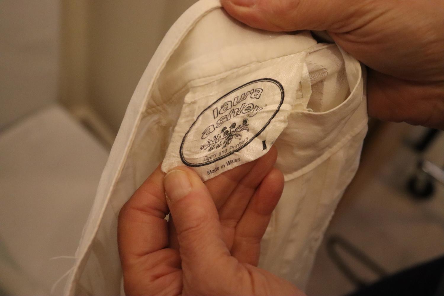 Un joli chemisier blanc vintage Laura Ashley. Ce chemisier fait partie de l'une de ses premières collections, à l'époque où elle fabriquait au Pays de Galles.  Elle s'ouvre par un bouton sur le devant, avec des plis et des détails en dentelle. Le
