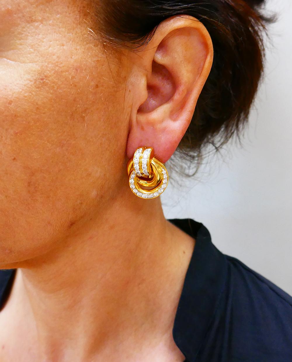 A gorgeous pair of French vintage earrings made of 18 karat gold and diamonds.
The earrings consist of two hoops hanging on a gold loop. One hoop is round, made of polished gold. Another hoop is embellished with round brilliant cut diamonds. The