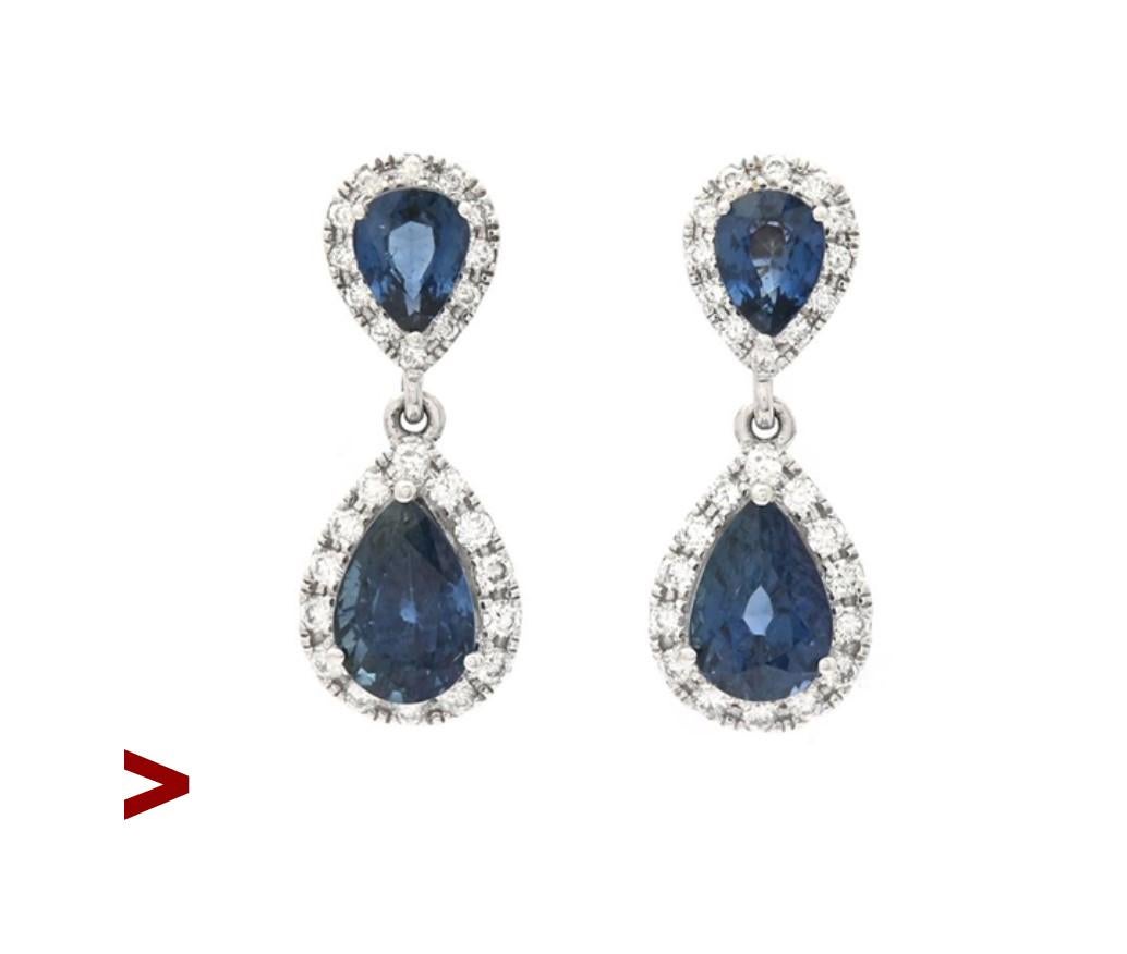 A pair of vintage dangles from ca. 1970s -1980s  in solid 18K  White Gold decorated with two pear cut natural Blue Sapphires 6 x 4 mm x 3.3 mm deep / ca  0.6ct  each and two smaller stones 4 mm x 3 mm wide x 2mm deep / ca. 0.2 ct each  or ca 1.6ctw