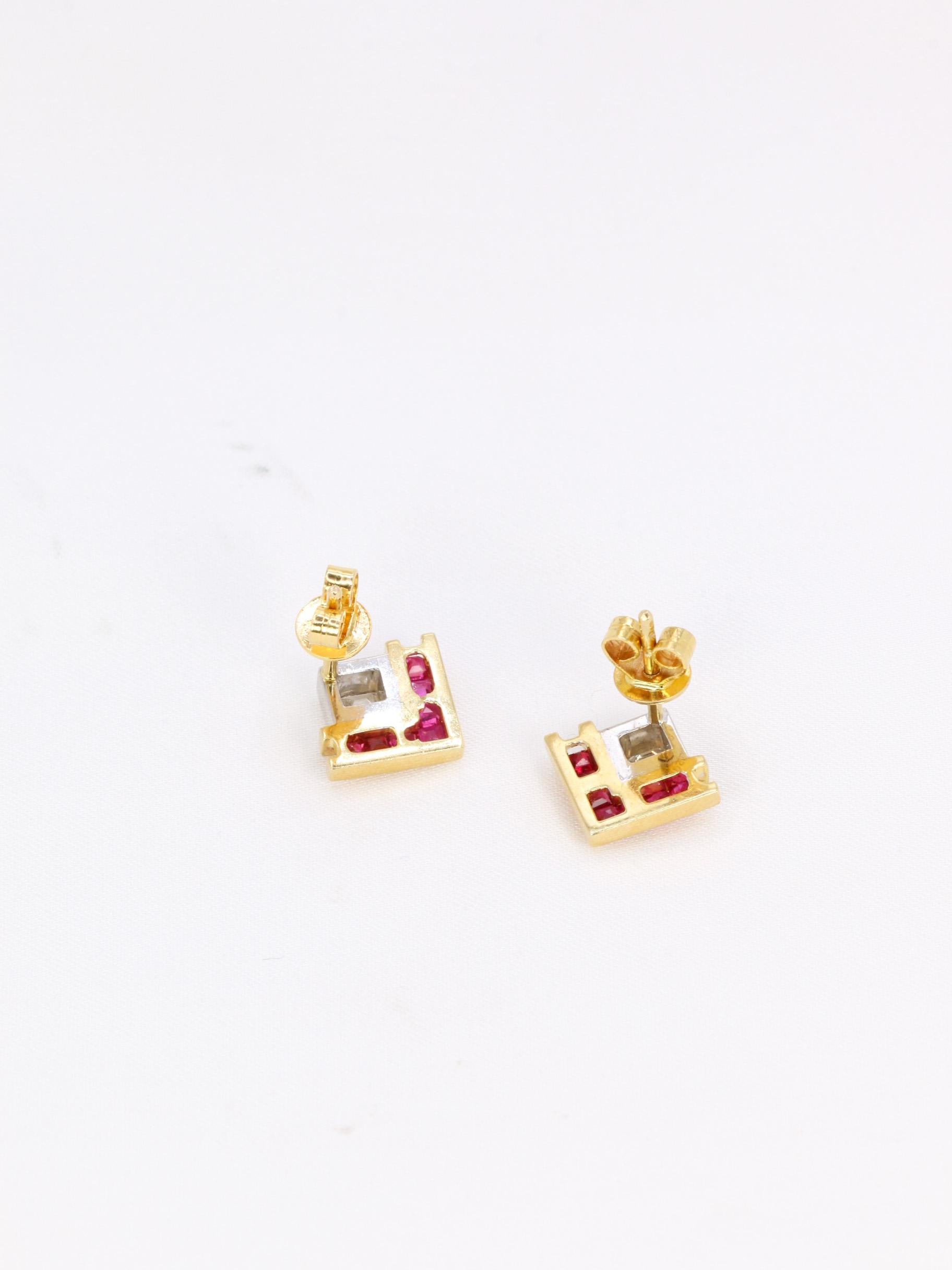 Geometric earrings in 18k (750°/°°) yellow and white gold set with a center emerald-cut diamond weighing approx. 0.20 carats of very fine DEF VS+ quality and 2 lines of calibrated rubies.
Probably vintage American work.

Very good condition, micro