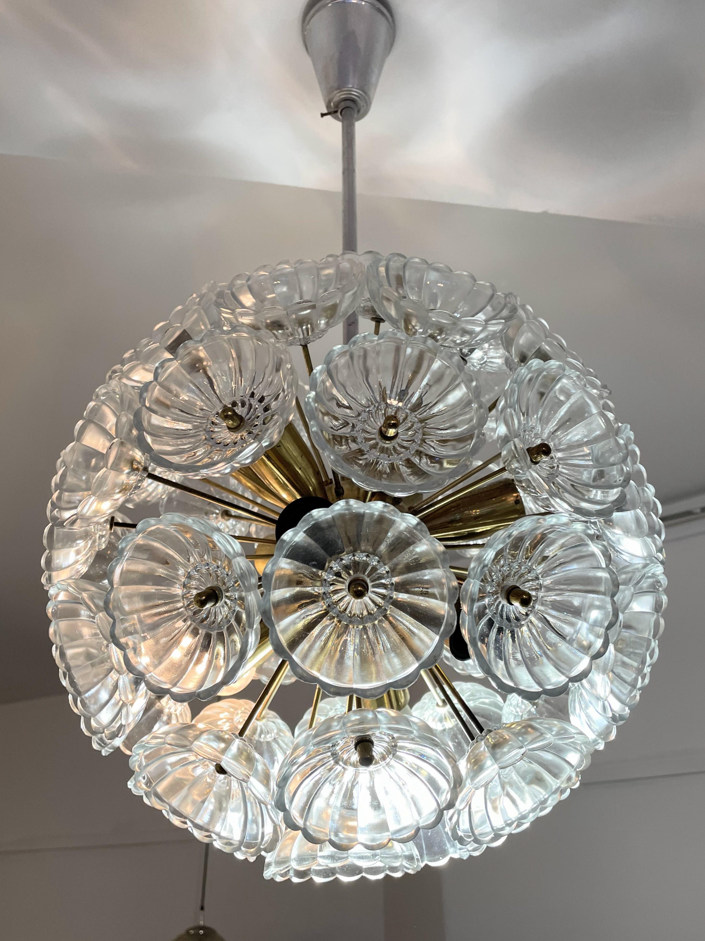 Un eccezionale lampadario vintage in ottone con 52 fiori in vetro spesso. Questa lampada in stile era appesa in passato nel Palazzo della Repubblica nella Germania dell'Est ed è un pezzo estremamente raro. Il disegno si basa su un dente di