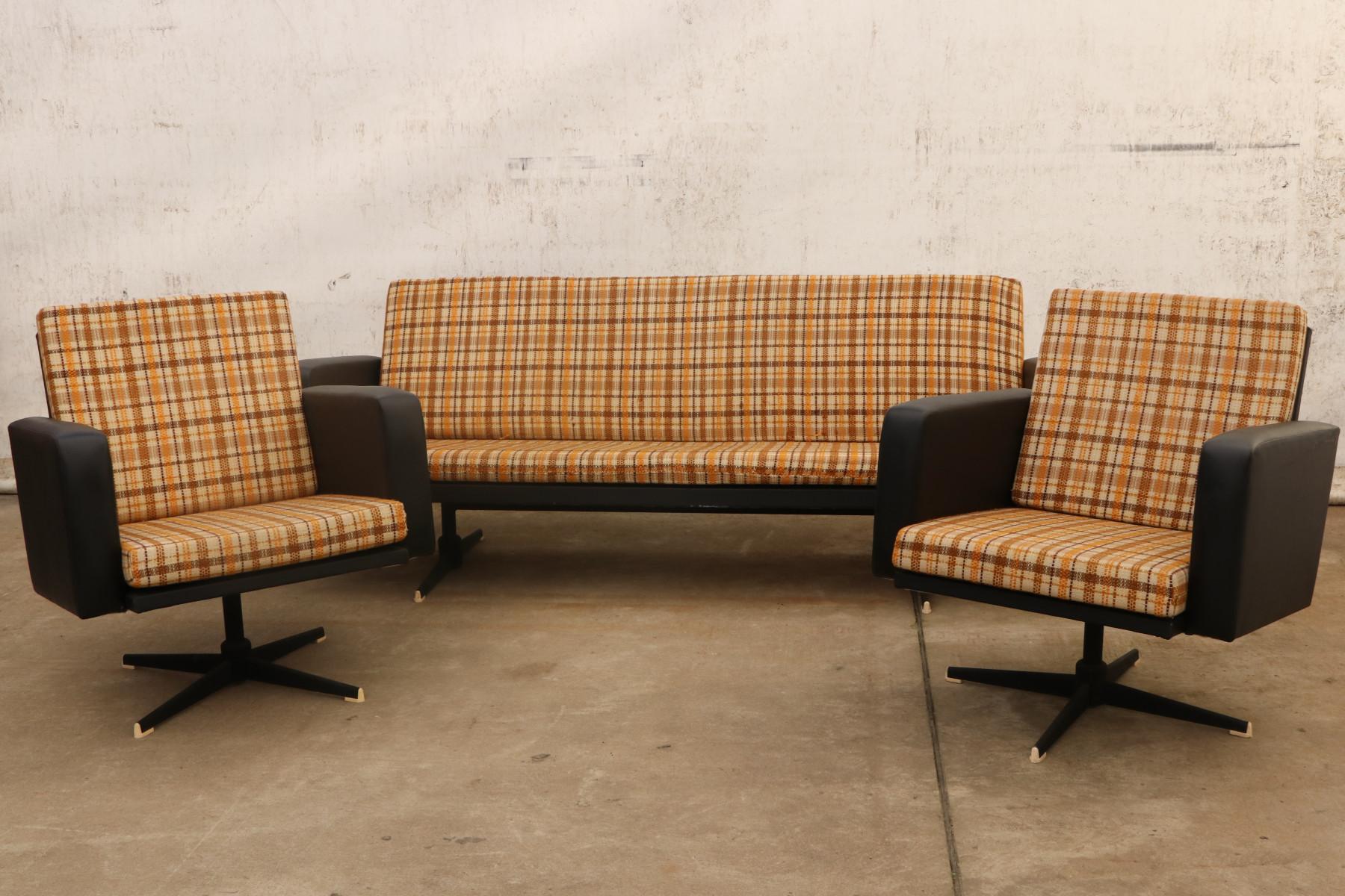 This lounge or office set was made in Czechoslovakia in the 1970s and consists of one sofa and a pair of swivel armchairs. The set is upholstered with brown leatherette and features original checkered fabric. The legs are made of iron. All is in