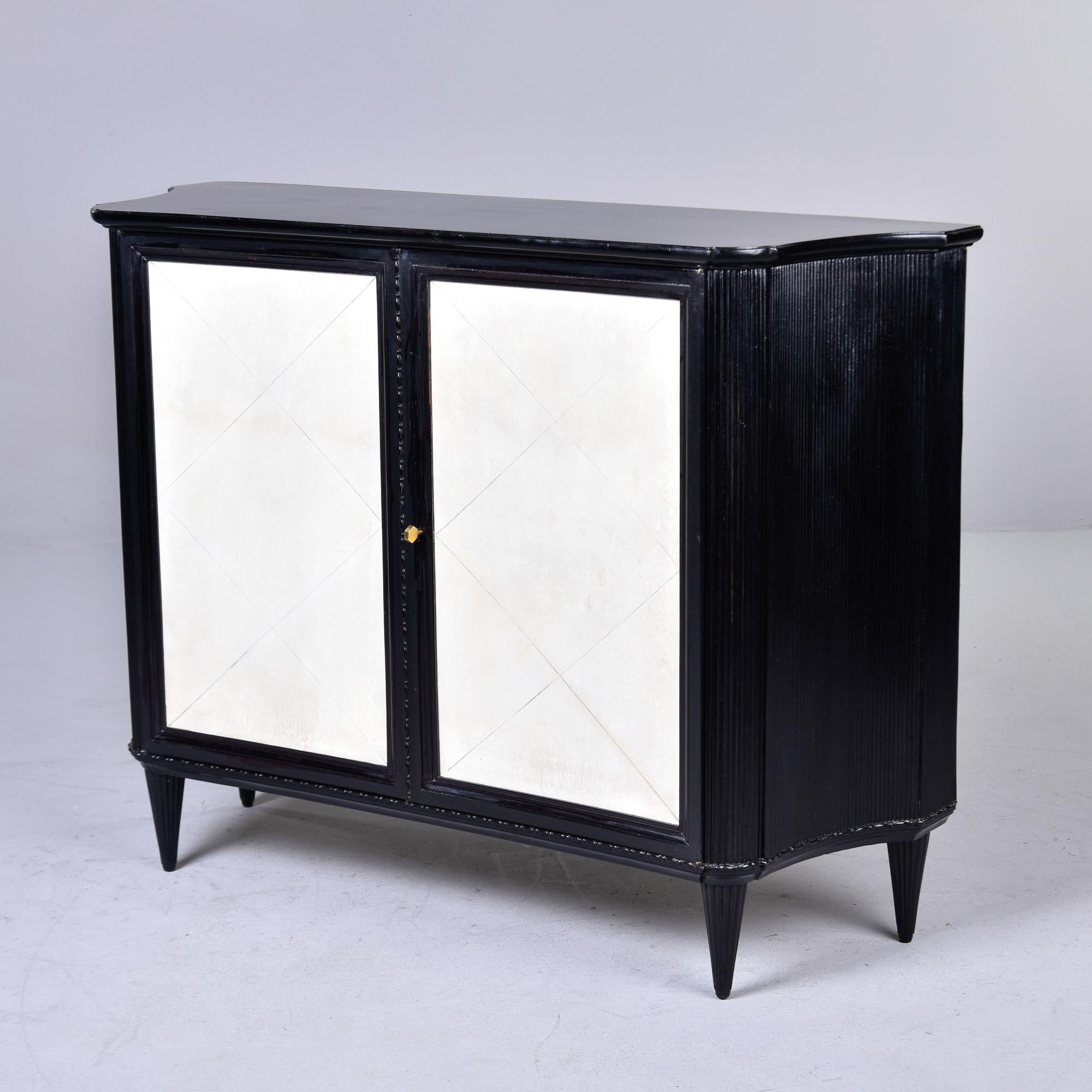 Found in Italy, this two door chest with ebonised frame and parchment doors dates from the 1960s. Outside of cabinet base has an ebonised finish. Two hinged, locking front doors have parchment fronts with diamond pattern. Doors open to wood stained