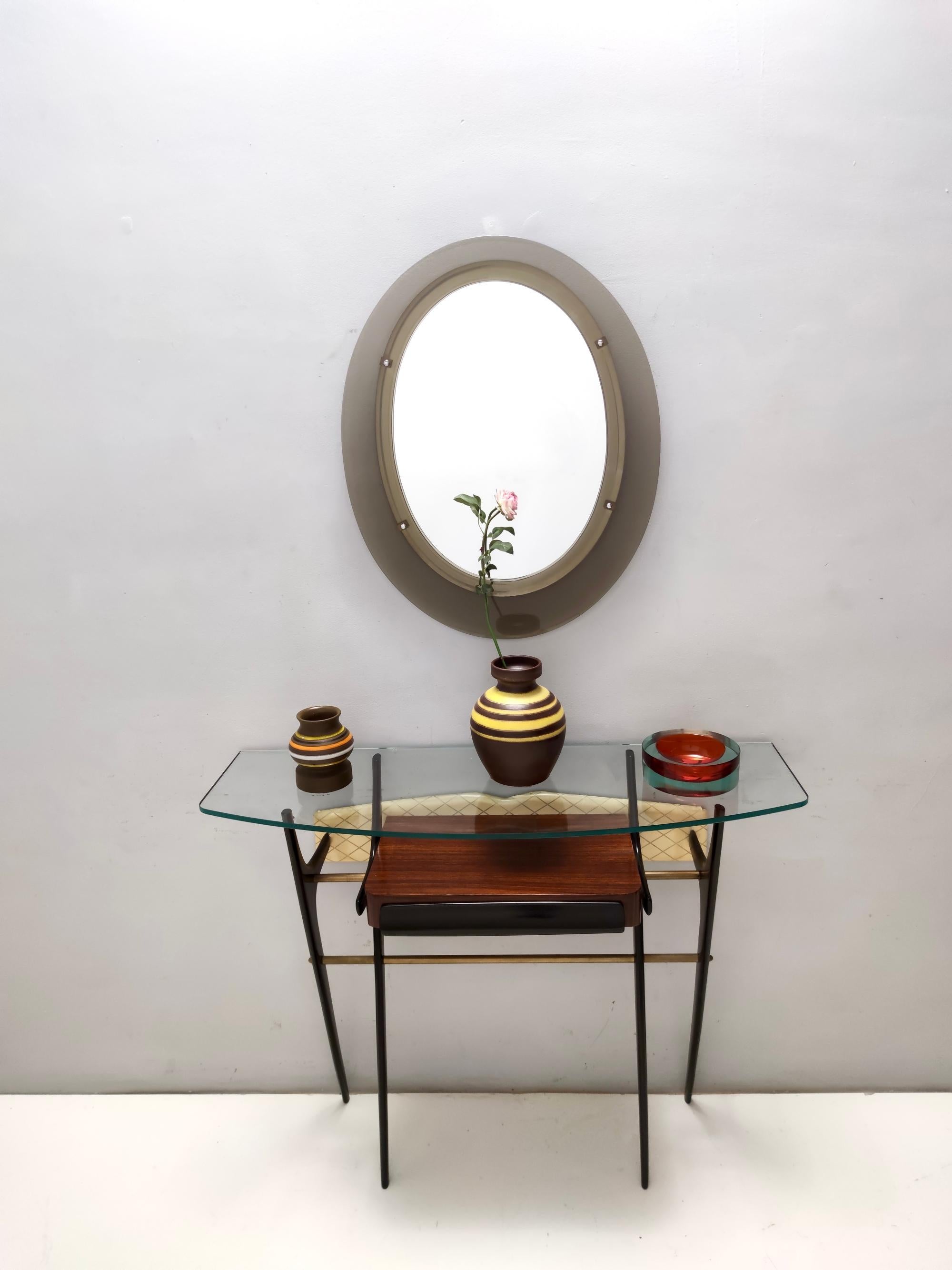 Made in Italy, 1950s. 
It features a polished and ebonized beech frame with brass details and a glass top.  
The console table might show slight traces of use since it's vintage, but it can be considered as in excellent condition with its original