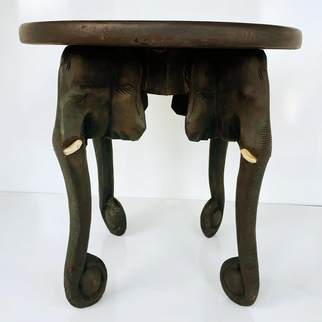 Table vintage en bois ébonisé et sculpté d'éléphants d'Afrique 

Nous proposons à la vente une table ronde africaine en bois noir ébonisé sculpté. Lourde et habilement sculptée, elle représente, comme les pieds de la table, quatre éléphants aux