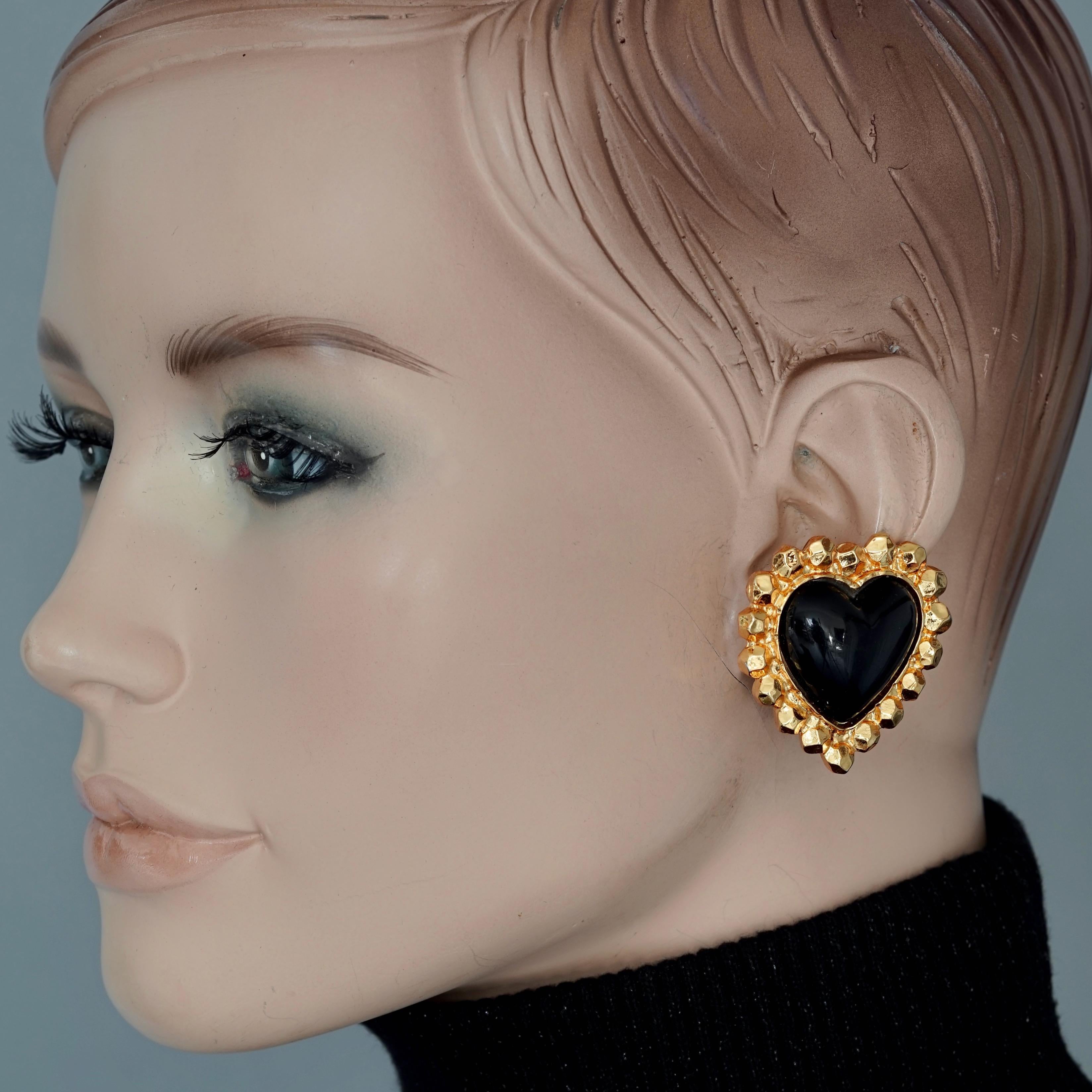 Vintage EDOUARD RAMBAUD Black Heart Earrings

Measurements:
Height: 1.57 inches (4 cm)
Width: 1.49 inches (3.8 cm)
Weight per Earring: 16 grams

Features:
- 100% Authentic EDOUARD RAMBAUD.
- Black resin heart earrings.
- Gold tone hardware.
- Clip