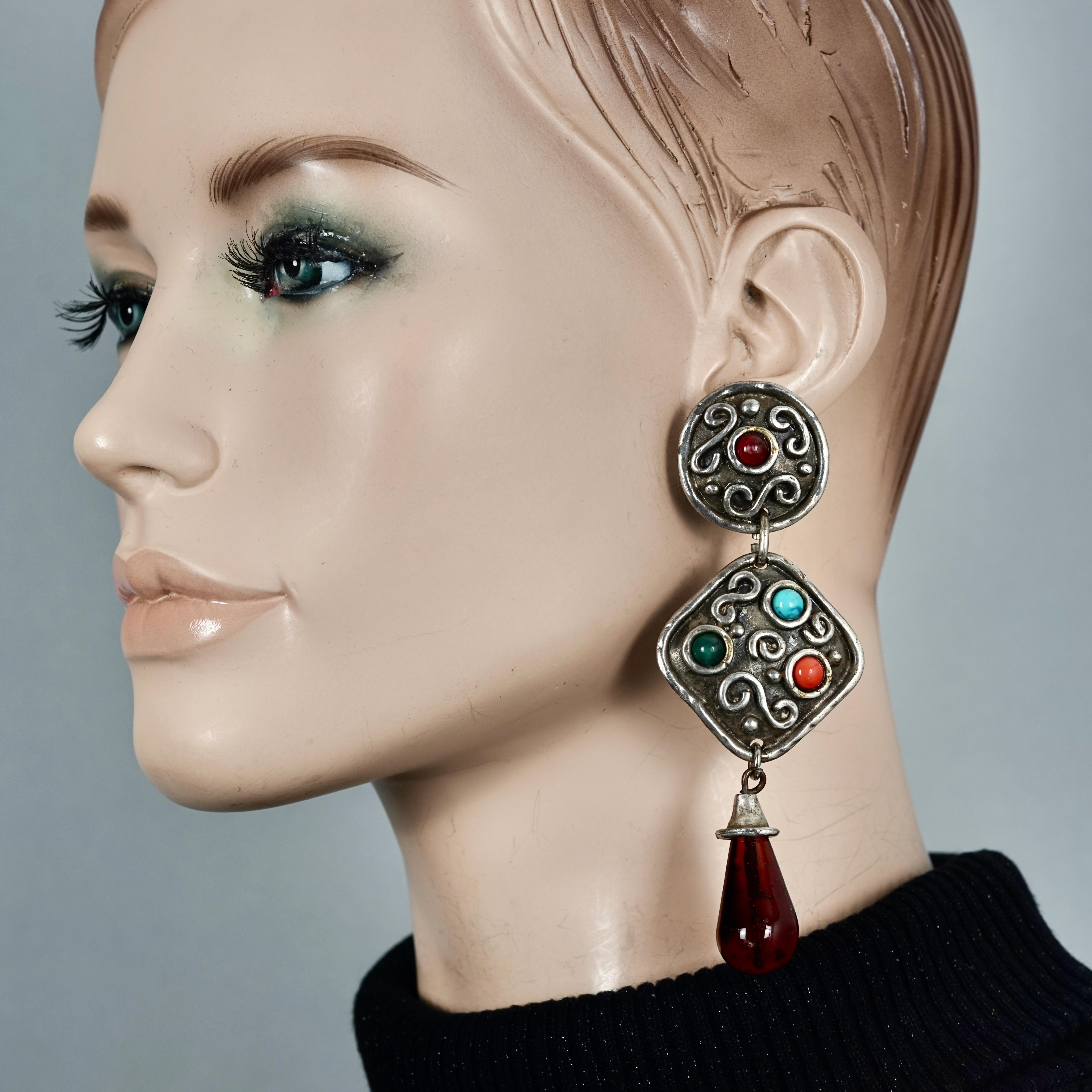 Vintage EDOUARD RAMBAUD Geometric Ethnic Dangling Earrings

Measurements:
Height: 4.33 inches (11 cm)
Width: 1.57 inches (4 cm)
Weight: 34 grams

Features:
- 100% Authentic EDOUARD RAMBAUD.
- Hammered geometric earrings embellished with dangling red