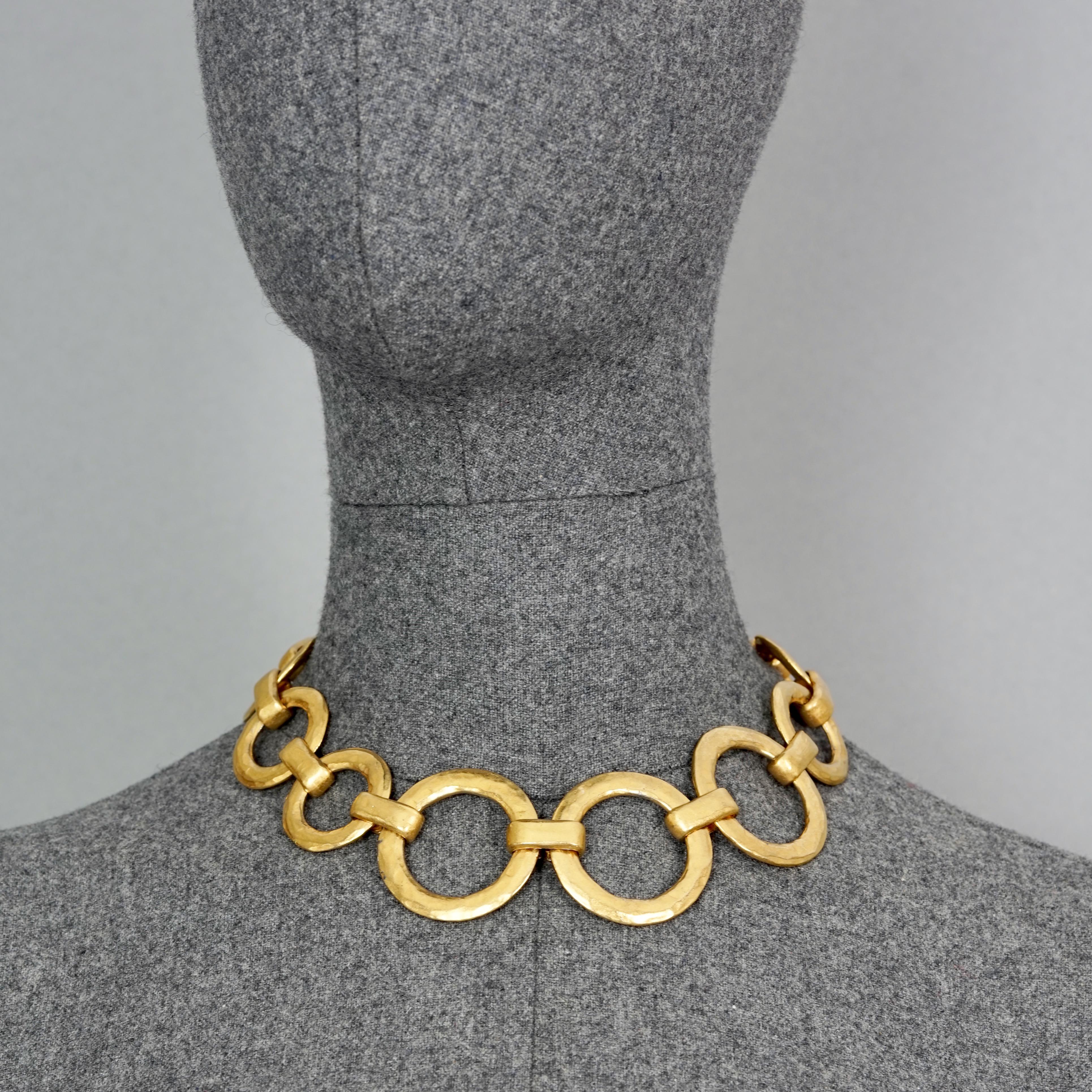 Vintage EDOUARD RAMBAUD Gilt Circular Link Necklace

Measurements:
Height: 1.57 inches (4 cm)
Wearable Length: 16.53 inches (42 cm)

Features:
- 100% Authentic EDOUARD RAMBAUD.
- Hammered gilt circular link necklace
- Gold tone hardware.
- Signed