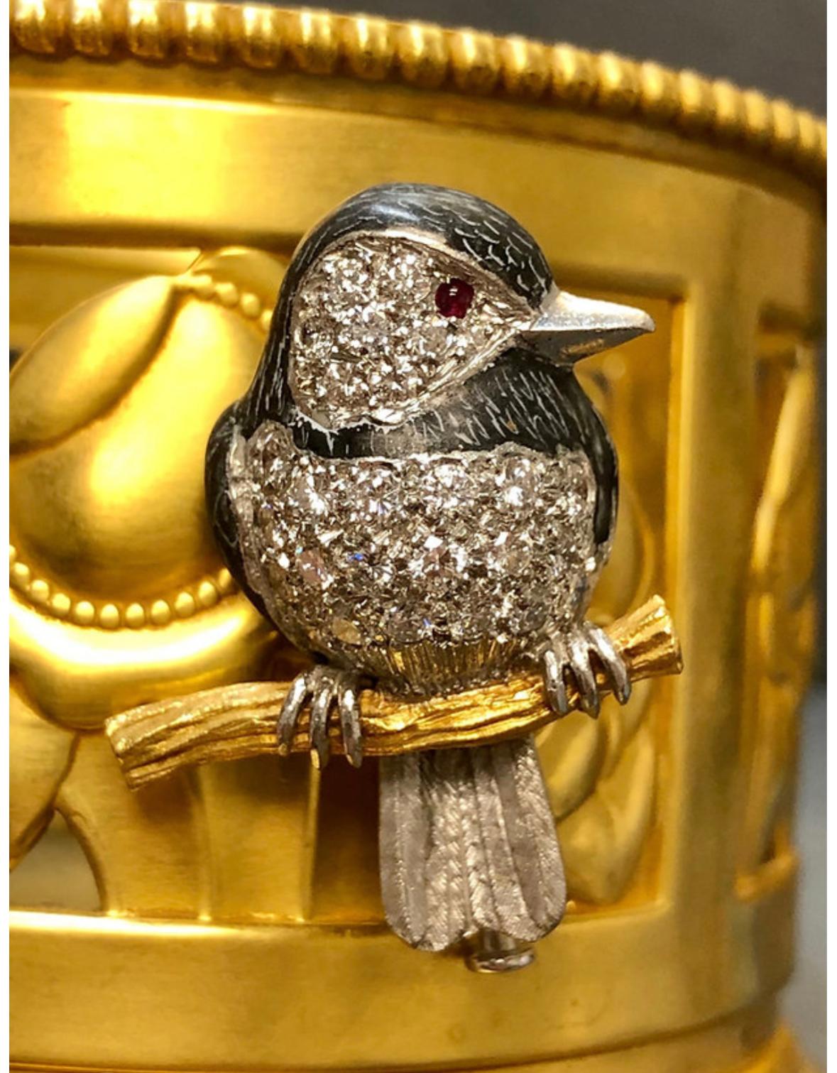 An incredibly detailed piece by Edward Wolfe & Co. done in 18K white and yellow gold as well as incredibly detailed black enamel and set with approximately 1.32cttw in G-H color Vs1-1 clarity round diamond and Ruby Cabochons for the
