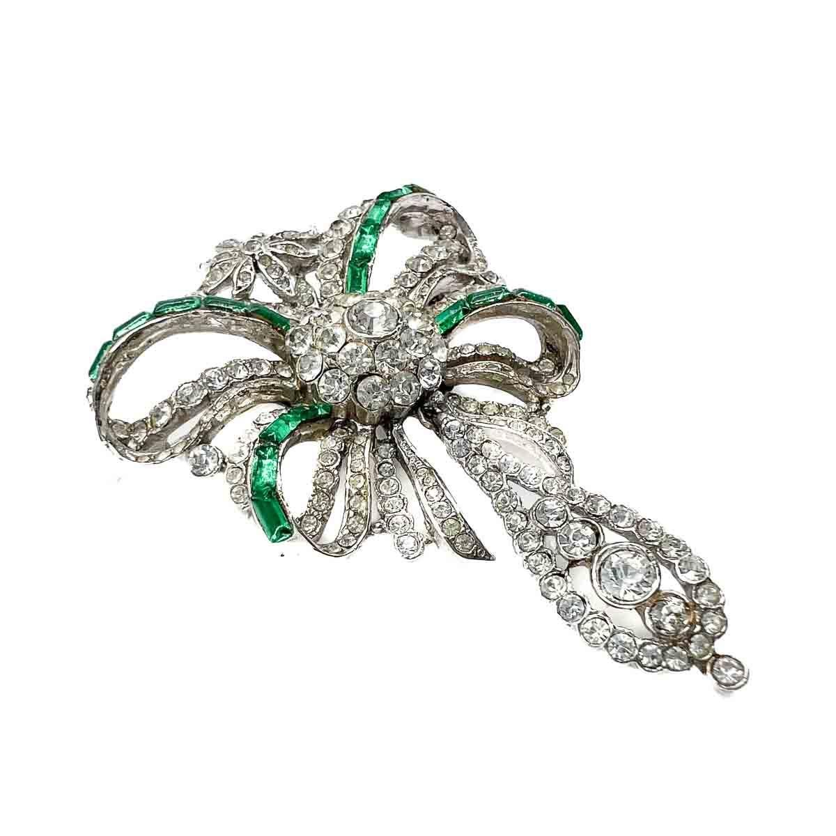 A delightful Vintage Edwardian Inspired Emerald Paste Brooch. Encrusted with stones, the double bow with drop design is eternally stylish and inspired by many aesthetic movements across the centuries, not least the Edwardian period. An elegant find