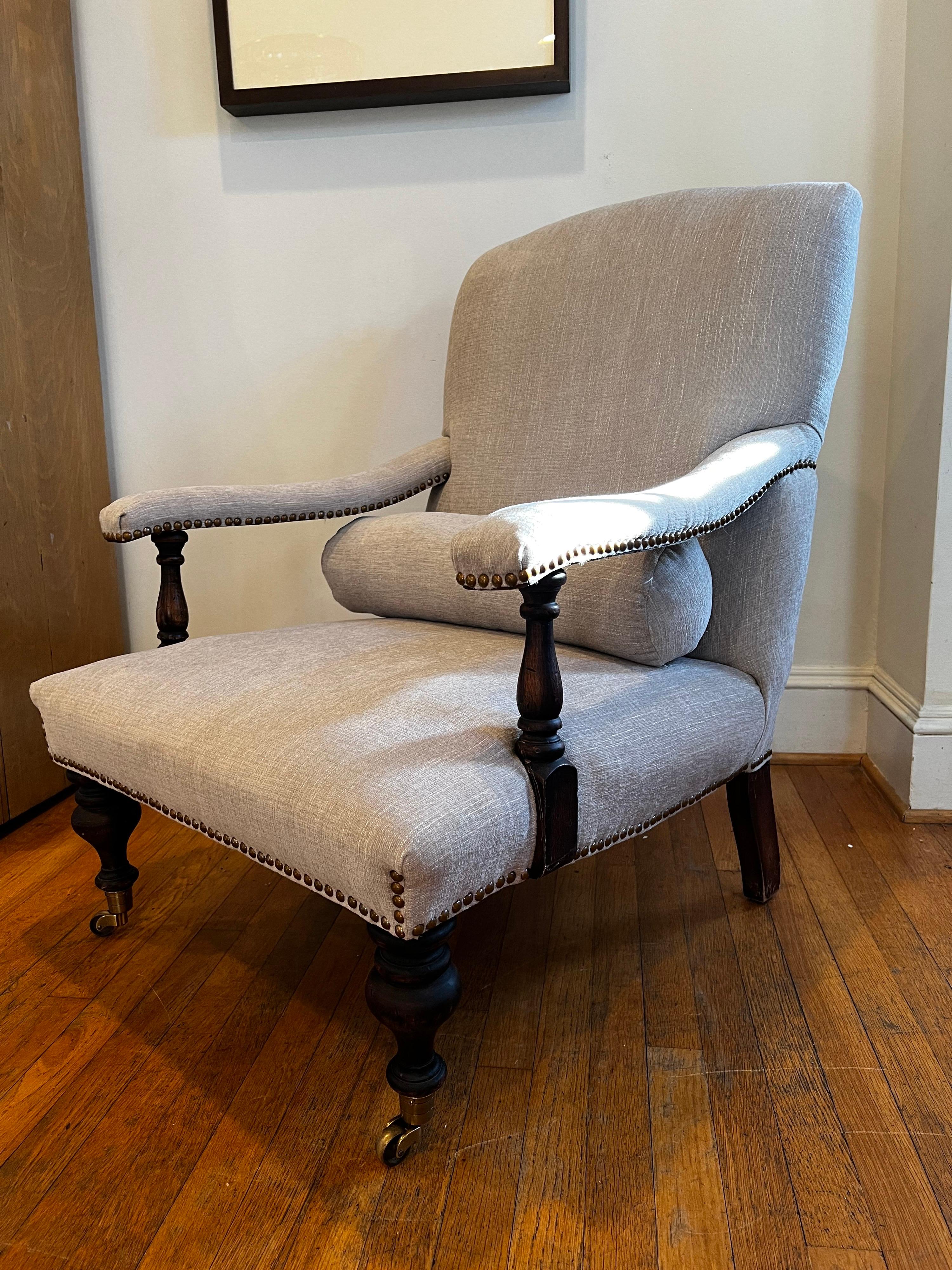 Beautiful Library/Reading armchair newly reupholstered in a light green/gray chenille fabric.
Handworked nailhead trim and brass castors on front two turned legs.

This was a custom made chair back in the early 90's and was recently