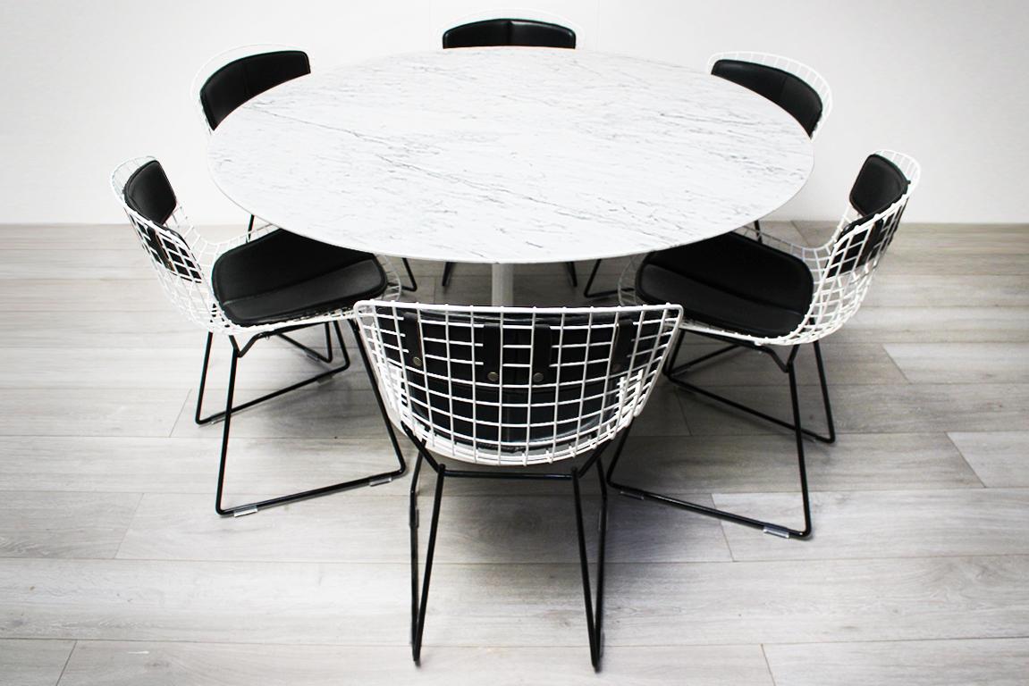 A Classic midcentury dining set comprising an white marble Eero Saarinen round tulip dining table matched to 6 white and black Harry Bertoia wire chairs - both produced by Knoll International.

This is a Classic combination of complimentary designs