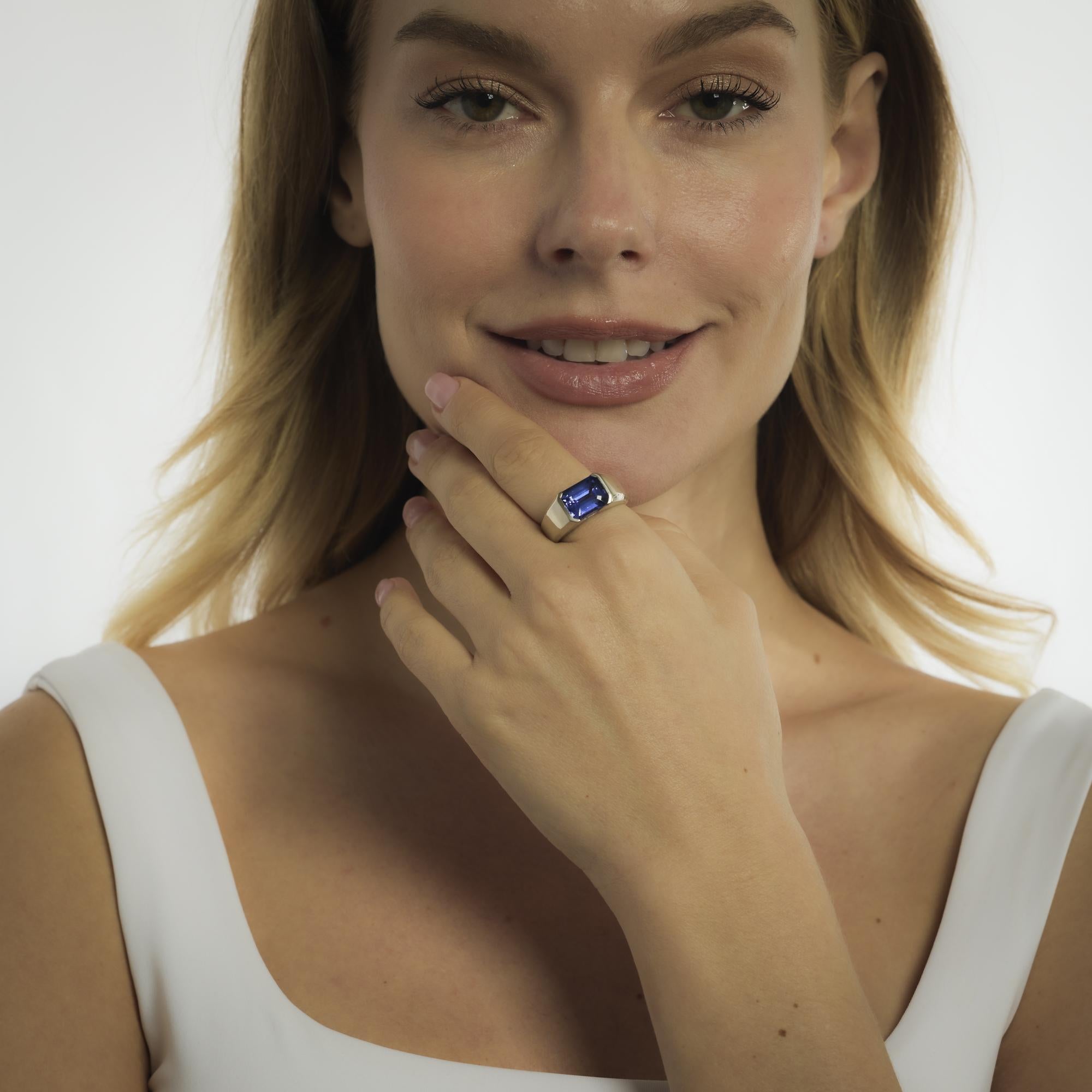 Dieser Vintage-Ring von Effy aus den 1980er Jahren ist mit einem 5,25-karätigen Tansanit im Smaragdschliff verziert, dessen violett-blauer Farbton durch die schlanke Geometrie des Schliffs noch verstärkt wird. Zwei Diamanten im Baguetteschliff von