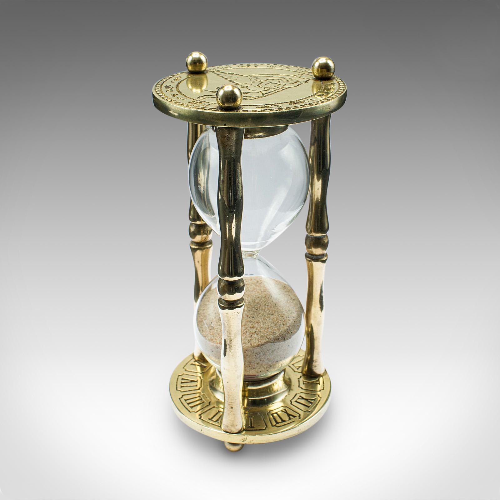 This is a vintage egg timer. An English, brass and glass 3 minute sand countdown, dating to the mid 20th century, circa 1960.

Charming vintage timer set within a polished frame
Displays a desirable aged patina throughout
Bright golden tones to