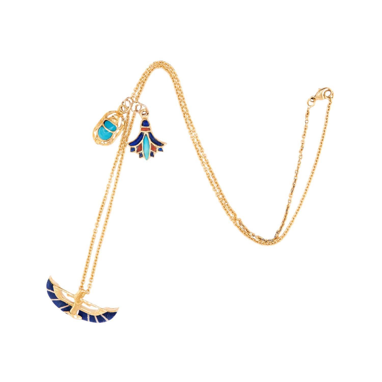 A wonderful charm necklace from the Vintage (ca1970s) era! Crafted in 18k vibrant yellow gold, this chain is decorated with 5 Egyptian motif charms. The first charm is a dainty scarab, whose abdomen is covered in teal enameling The second, central