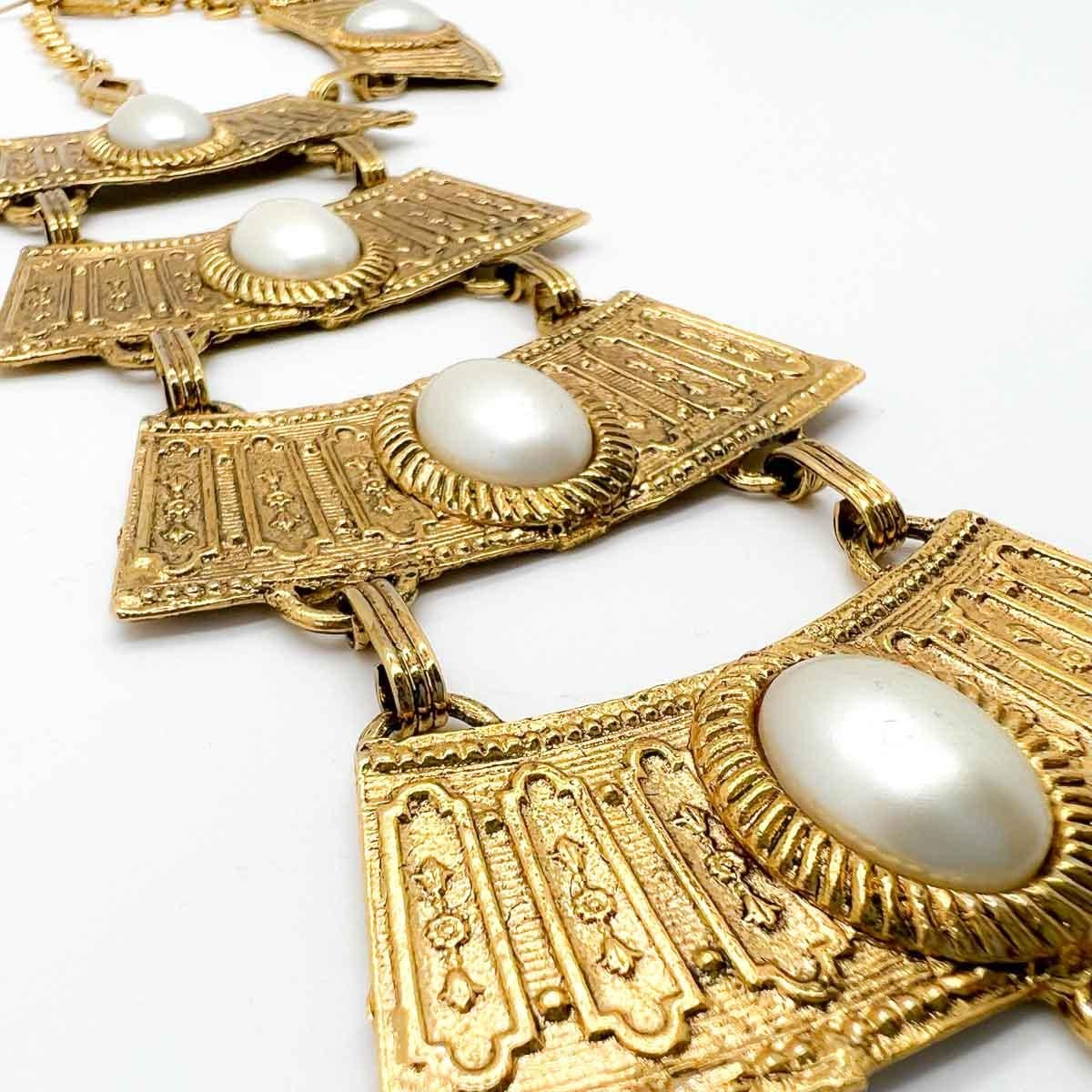 A rare and dramatic vintage Egyptian Grand Bib. Exquisite Egyptian inspired detailing beautifully contrasted by the large oval pearls. Make a statement with this stunning piece of wearable art.
An unsigned beauty. A rare treasure. Just because a