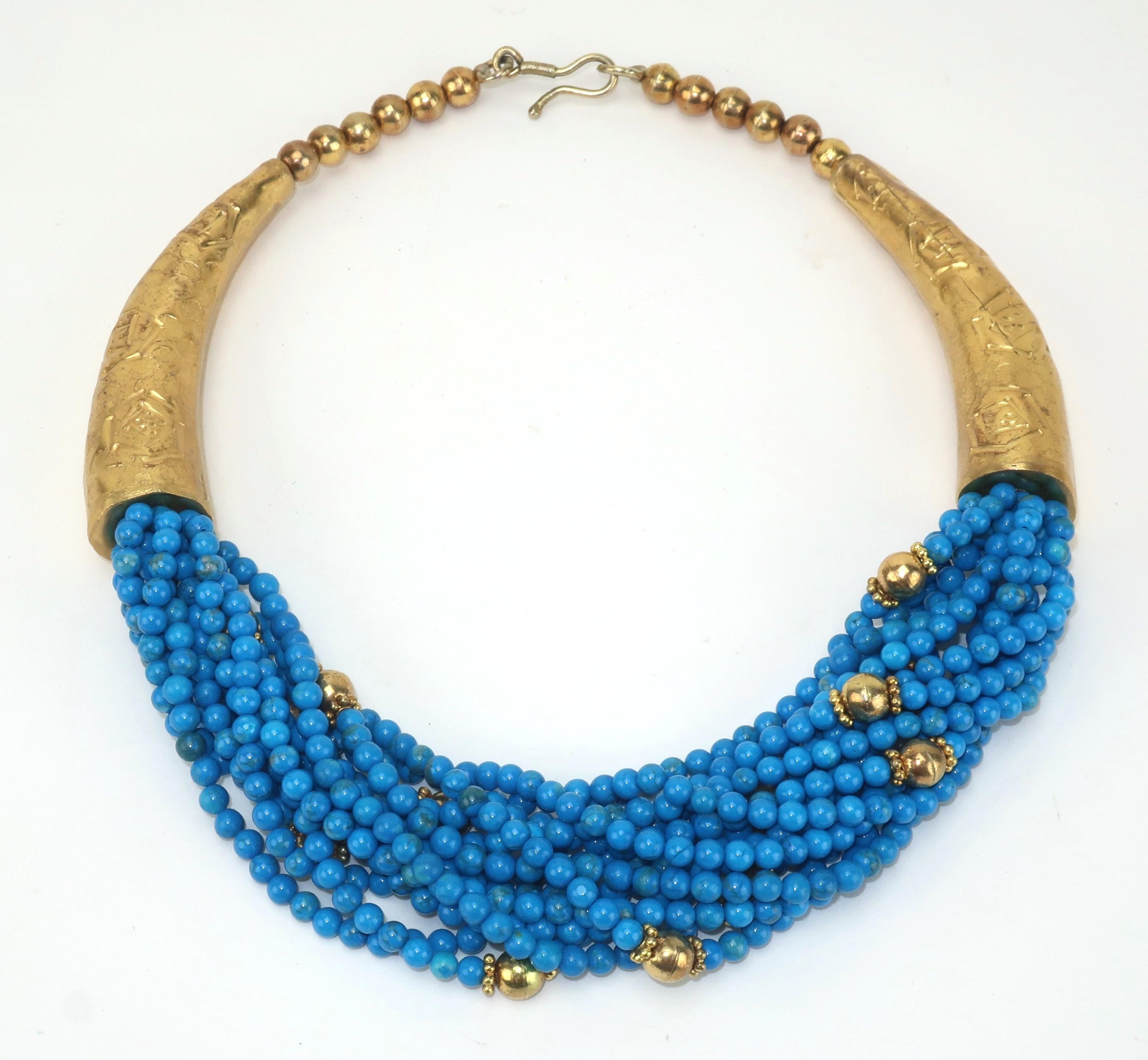 Vintage multi-strand collar necklace designed with bright blue beads and gold tone metal accents.  Outfitted with a J-hook and unsigned.  The former owner purchased this lovely piece in Egypt and indeed it has a wonderful North African aesthetic. 