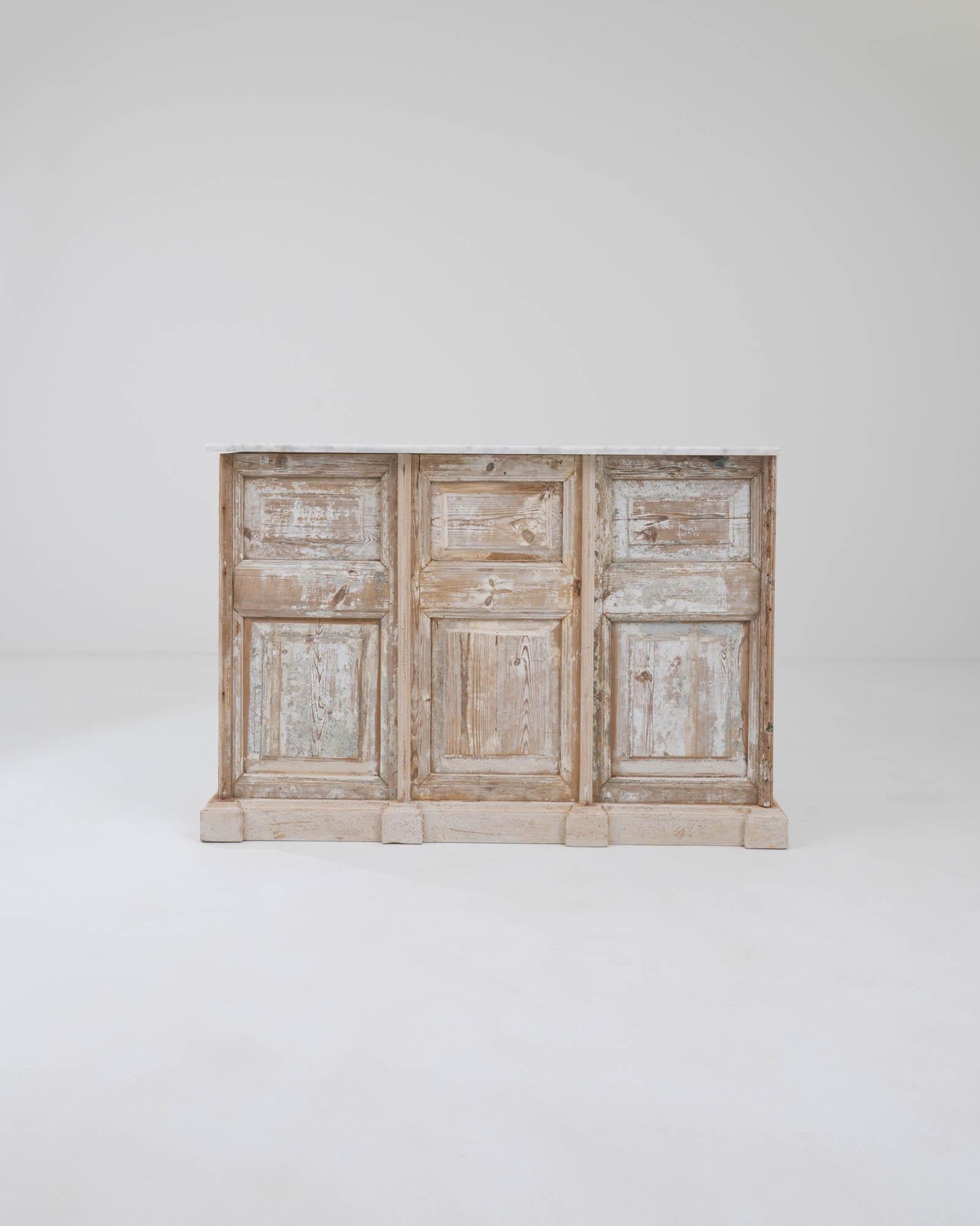 Sourced in Northern Africa, this striking patinated bar was constructed by artisans from vintage wooden doors. Formerly serving as entryways and passages in the imposing palatial townhomes where these paneled doors were once commonplace. The