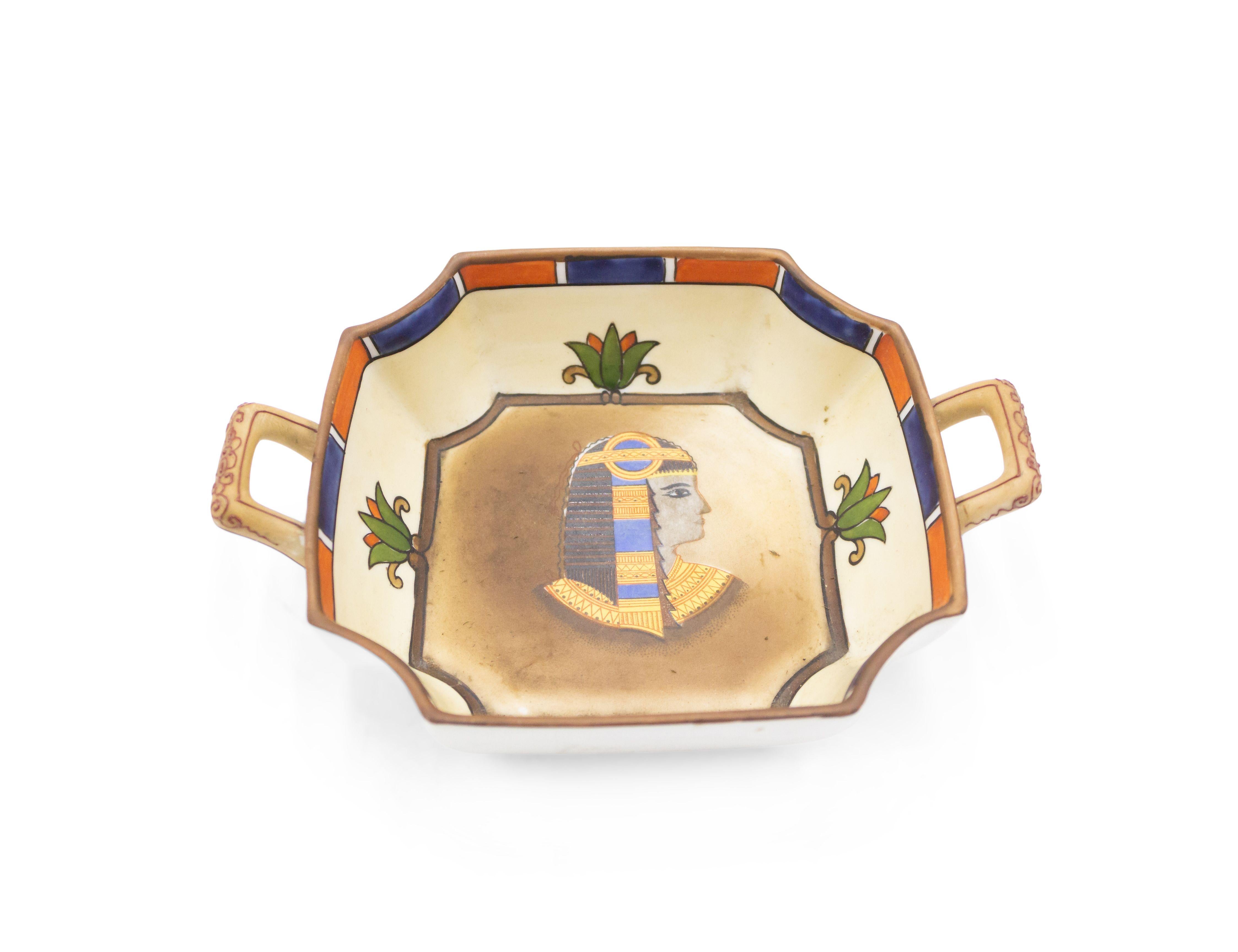 Quadratischer Aschenbecher aus Porzellan im ägyptischen Stil des Nahen Ostens (1930er Jahre) mit kleinen vergoldeten Henkeln und klassischer Büste in der Mitte (NIPPON).
 