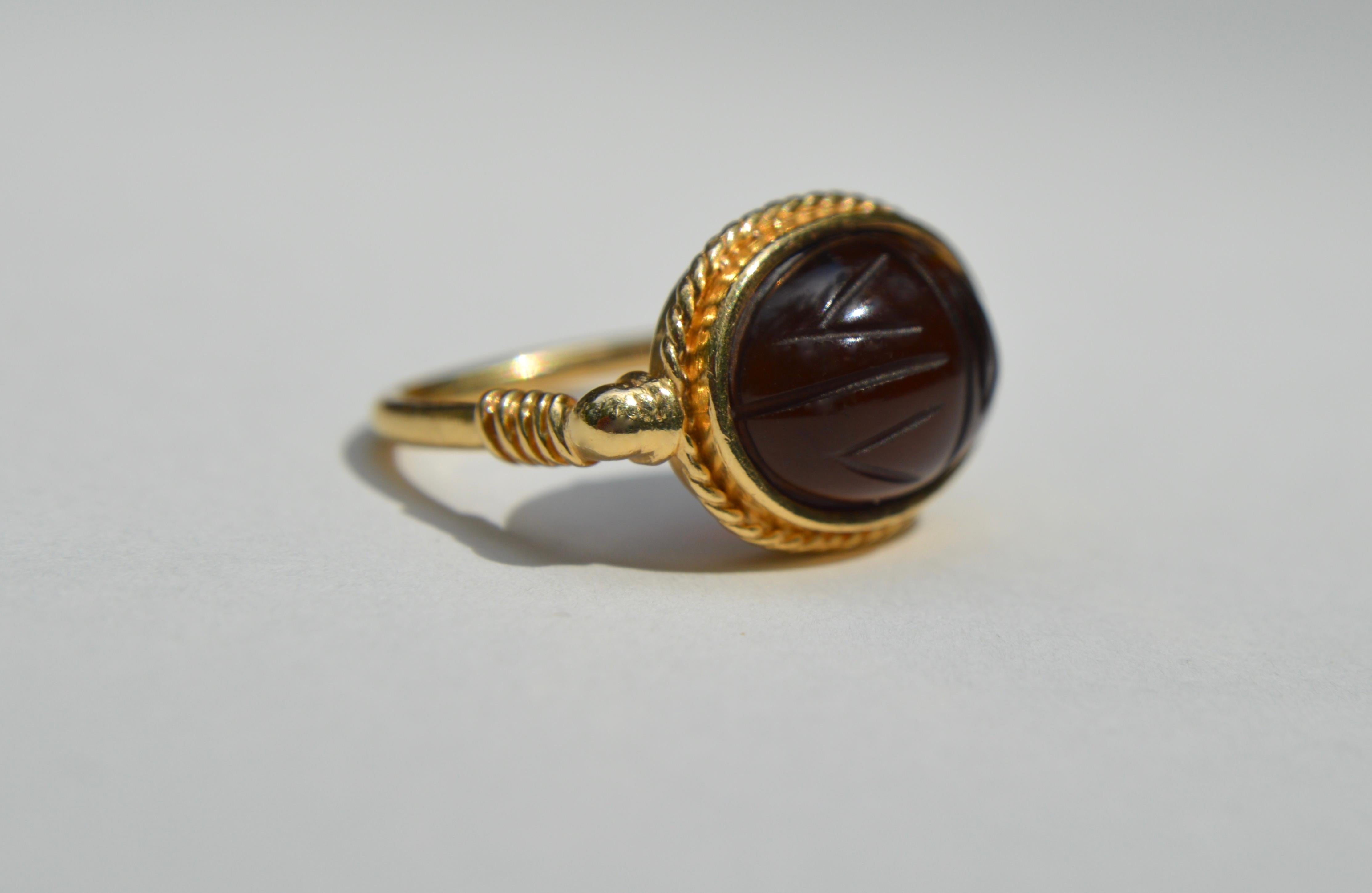 Beautiful vintage c1990s Egyptian revival, rich root beer hued Baltic amber carved scarab beetle ring in 14K yellow gold. Size 6.5. In excellent condition. Marked as 14K and Multilana (a fine jeweler specializing in museum reproductions). Amber
