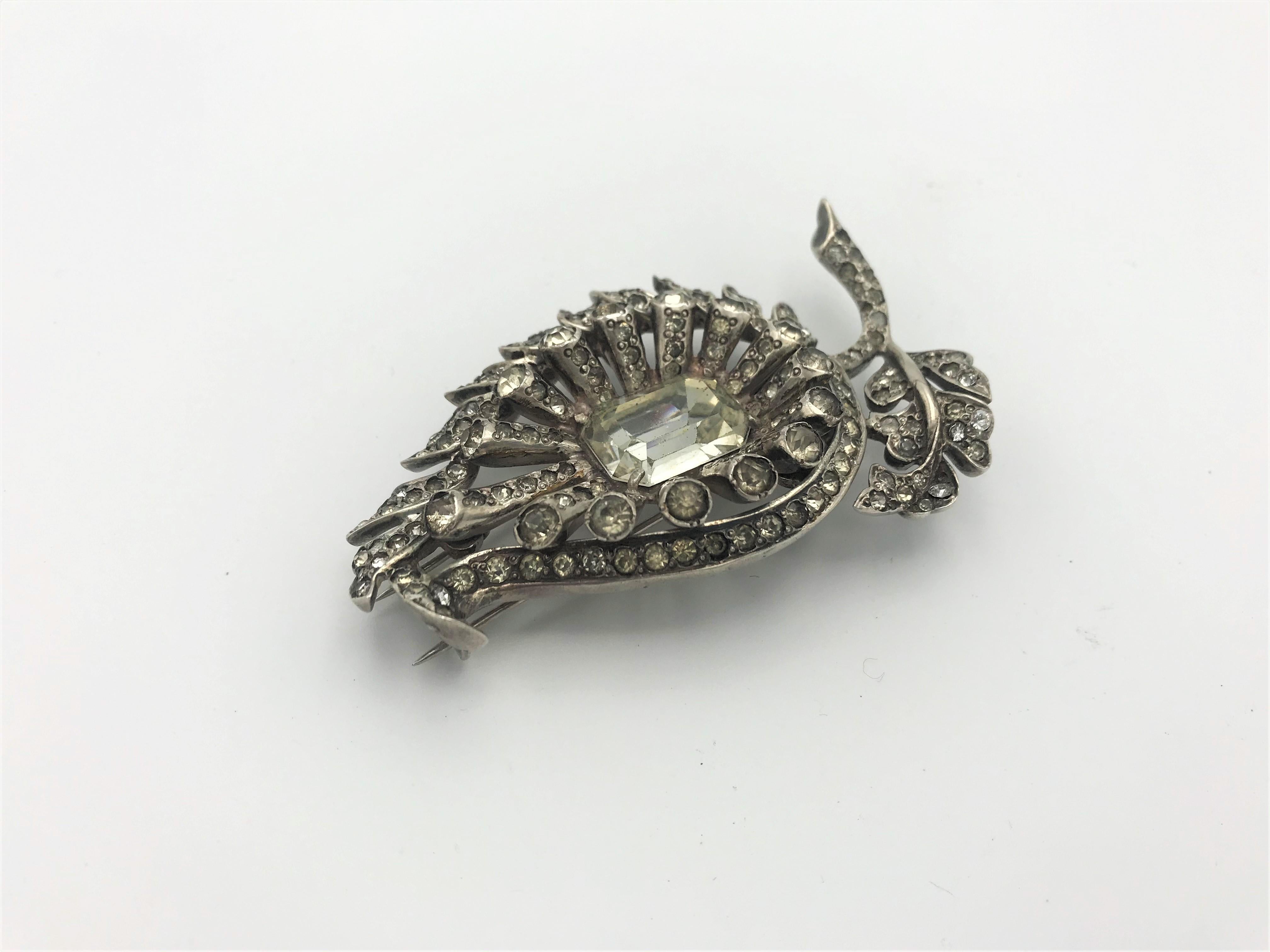 A very early piece by Eisenberg in the shape of a pear with a leaf by. Very three-dimensional worked with a lot of rhinestones and a large cut rhinestone by Swarovski in the middle. The cloth clip is made of sterling und signed EISENBERG and