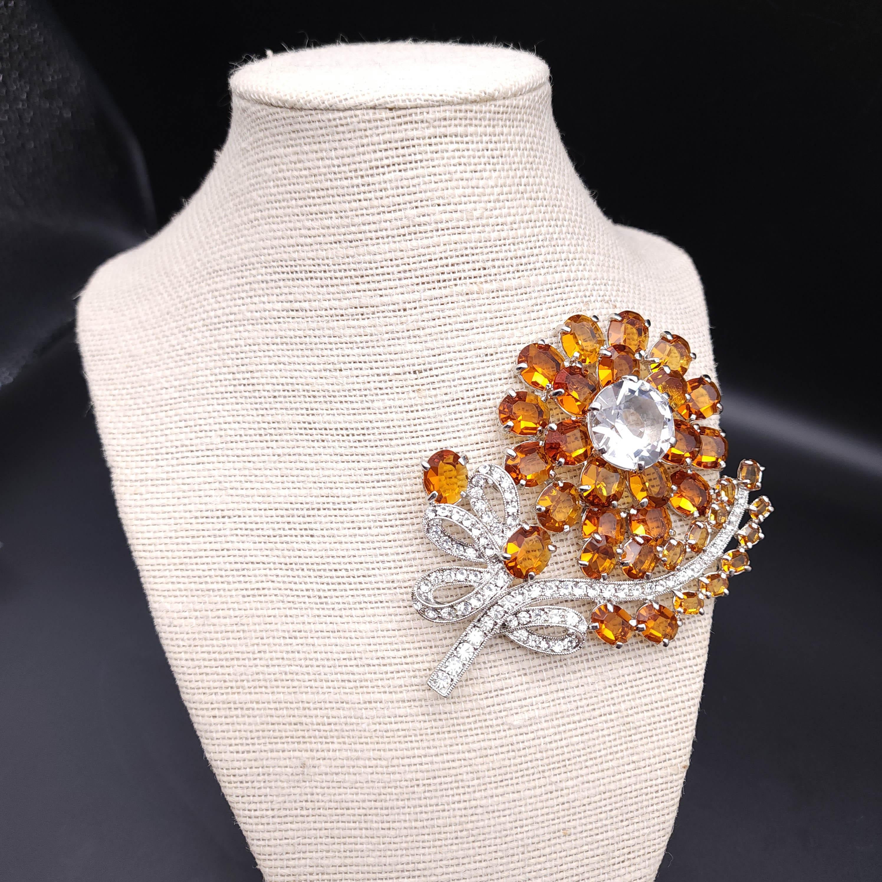 Elevate your ensemble with the timeless elegance of this vintage Eisenberg Ice pin! 

Crafted in a radiant silver tone, this exquisite brooch showcases a dazzling flower adorned with large prong-set topaz crystals that capture the light with every