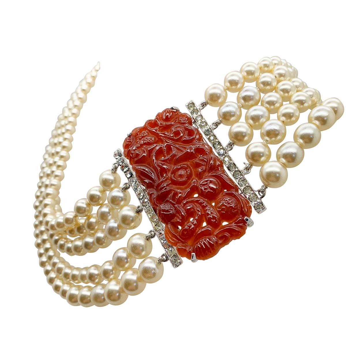 A rare and breath-taking vintage Eisenberg carved plaque necklace from the 1940s. Featuring a splendid five lustrous strands of graduated glass pearls. The crowning glory of this piece, an important and impactful art deco style carved carnelian