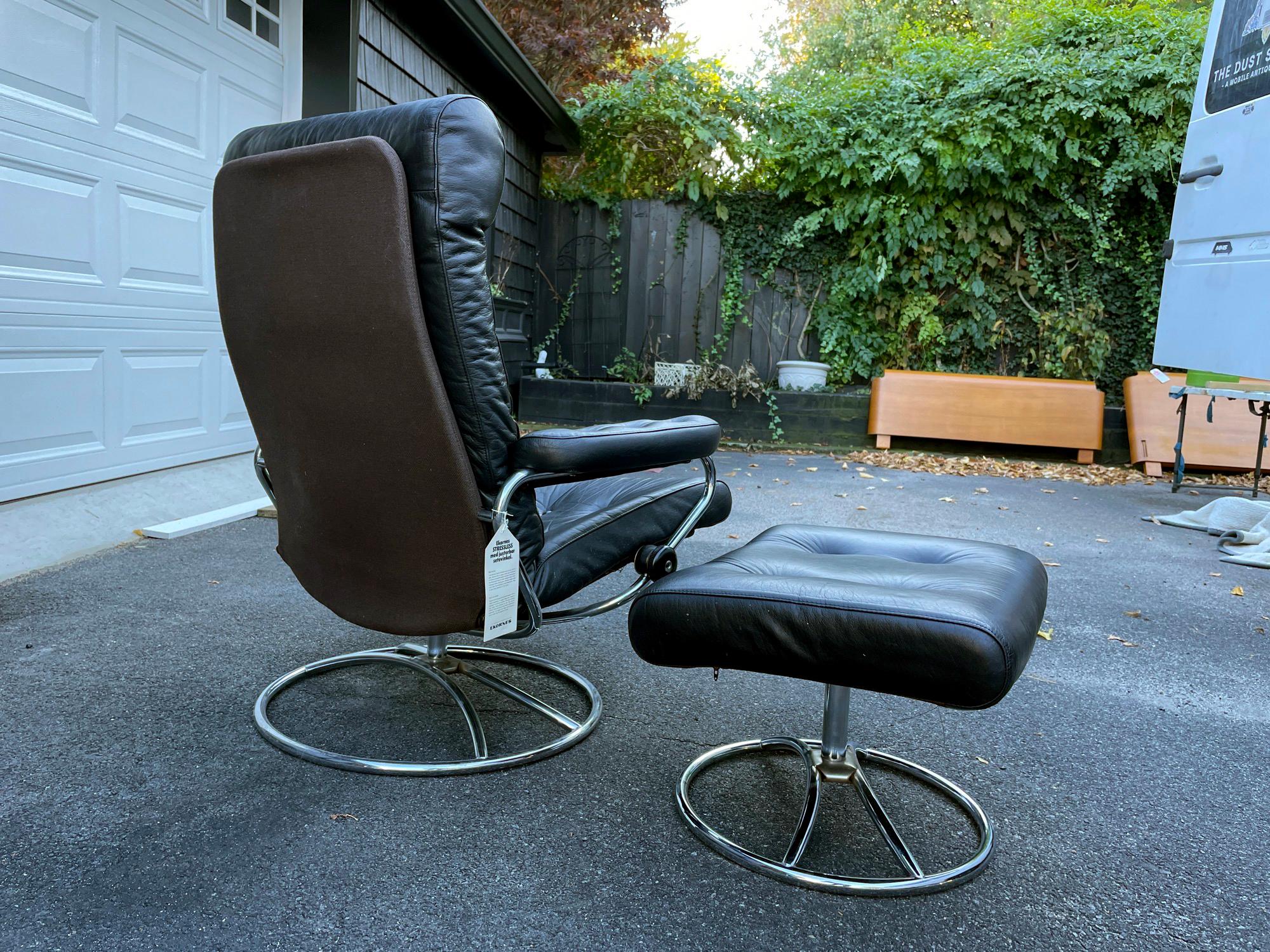 An early model Ekornes Stressless chair from Norway upholstered in black leather. Base is in beautiful condition with no pitting. Reclines deeply and is very comfortable. Includes original hangtag! No rips or cracking to the leather. A wonderful