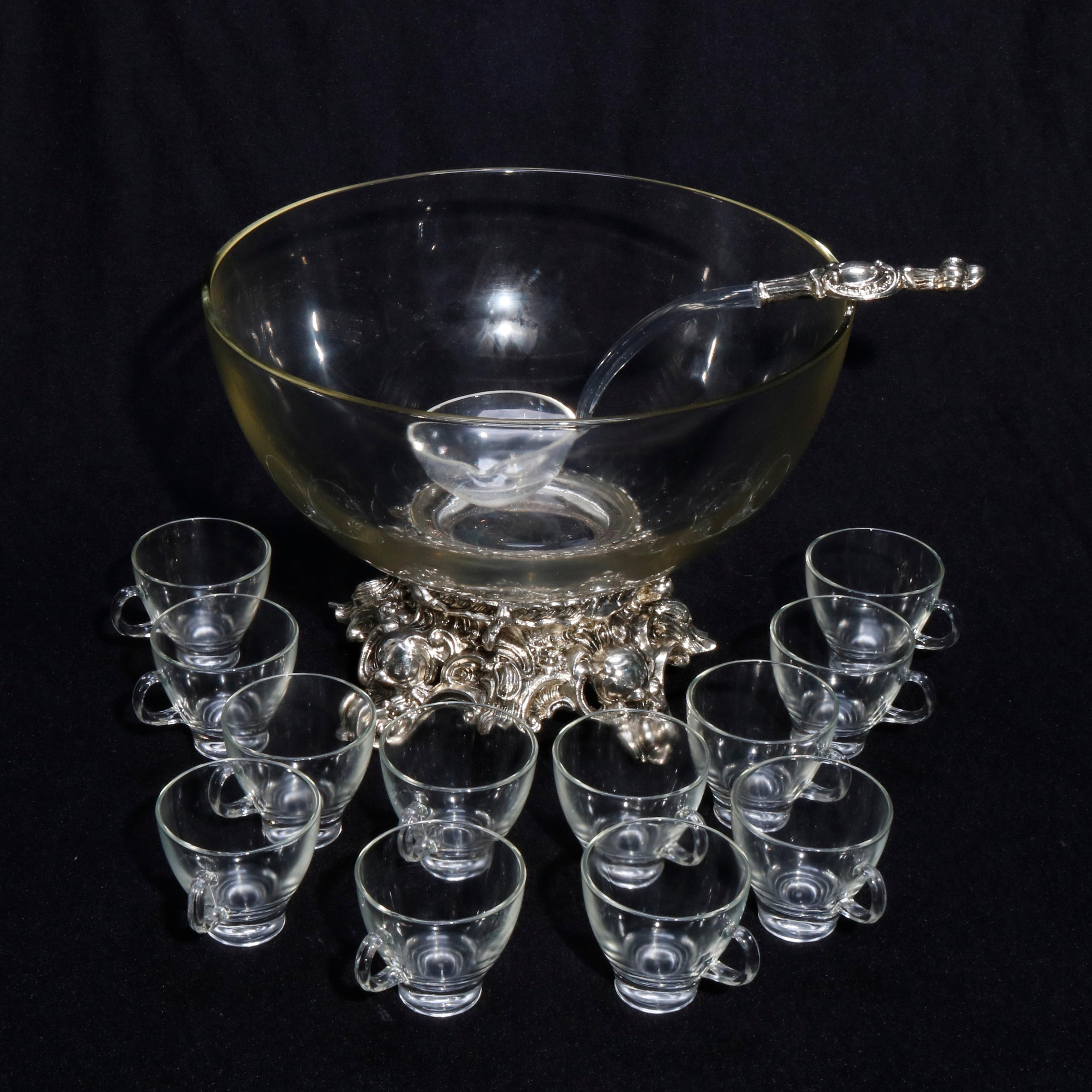 A vintage punch bowl set offers elegant glass serving bowl seated on silver plate foliate and scroll form footed base and includes 12 handled glass cups and matching ladle, circa 1950

Measures - punch bowl: 9.25