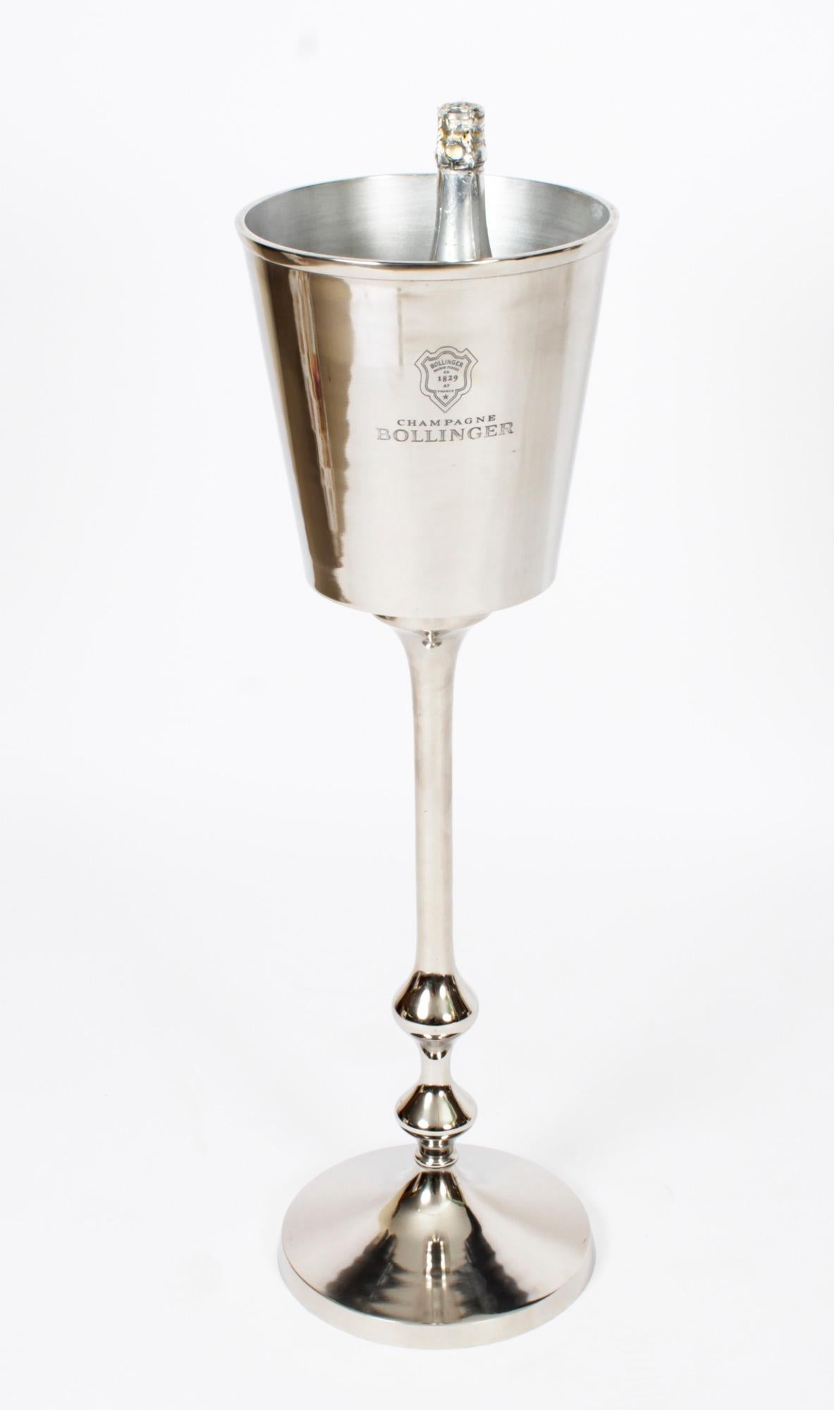 This is a fabulous vintage silver plated Bollinger champagne / wine cooler on stand, late 20th Century in date.
 
It features a tapering cylindrical bucket engraved with 'Bollinger Champagne Maison Fondee 1829' raised on a tapering stand with a
