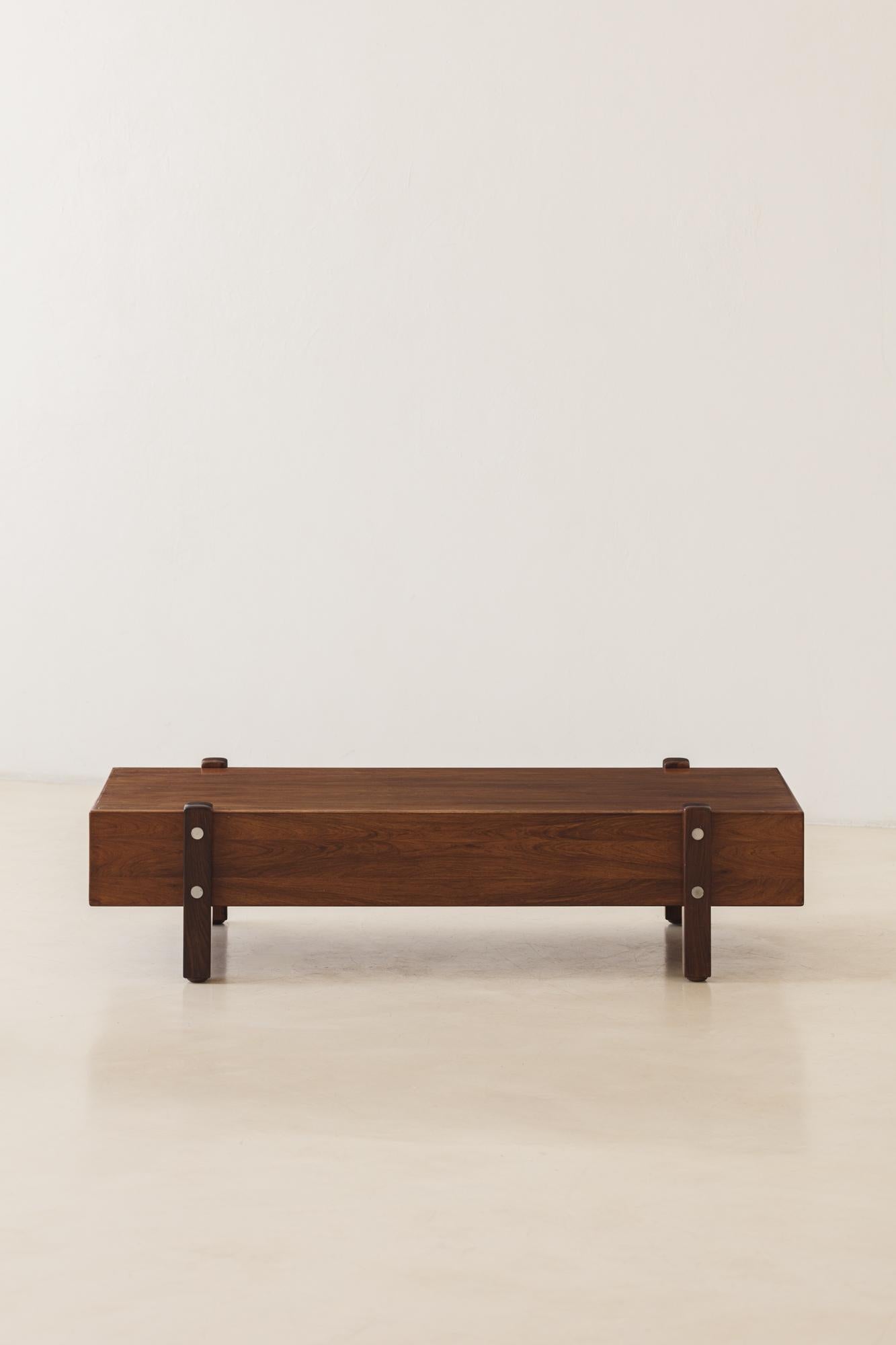 The Eleh bench is a furniture piece from the 1960s designed by Sergio Rodrigues (1914-2012). Its structure is composed of a veneered wood box covered with Rosewood veneers and four solid Rosewood feet with chromed details. Like many designers of