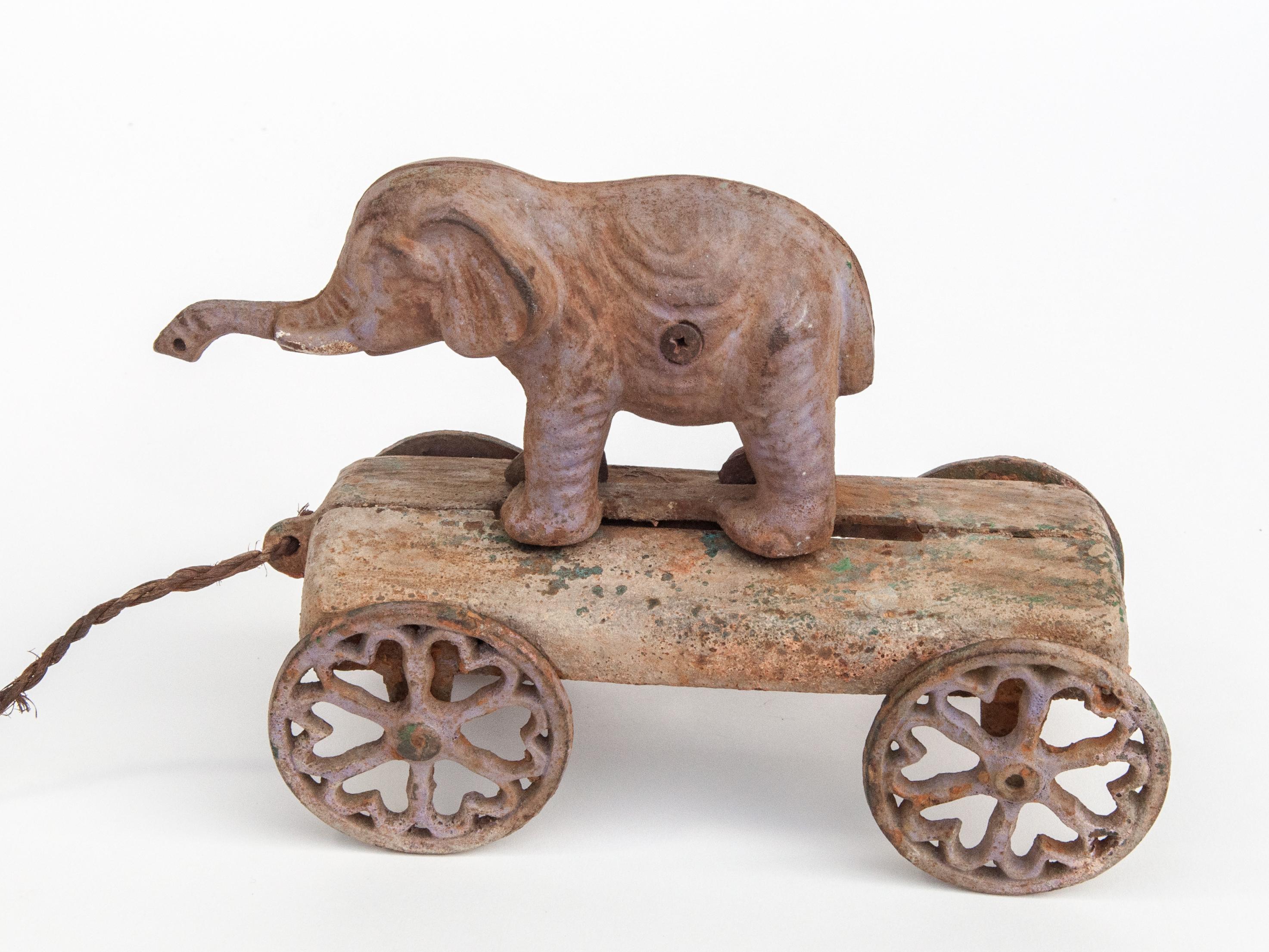 Vintage elephant pull toy. Cast Iron. Early 20th century. USA.
Offered by Bruce Hughes.
When pulled the turning wheels cause the elephant figure to move forwards and backwards.
Condition: Good condition. Some rust and deterioration of color, but