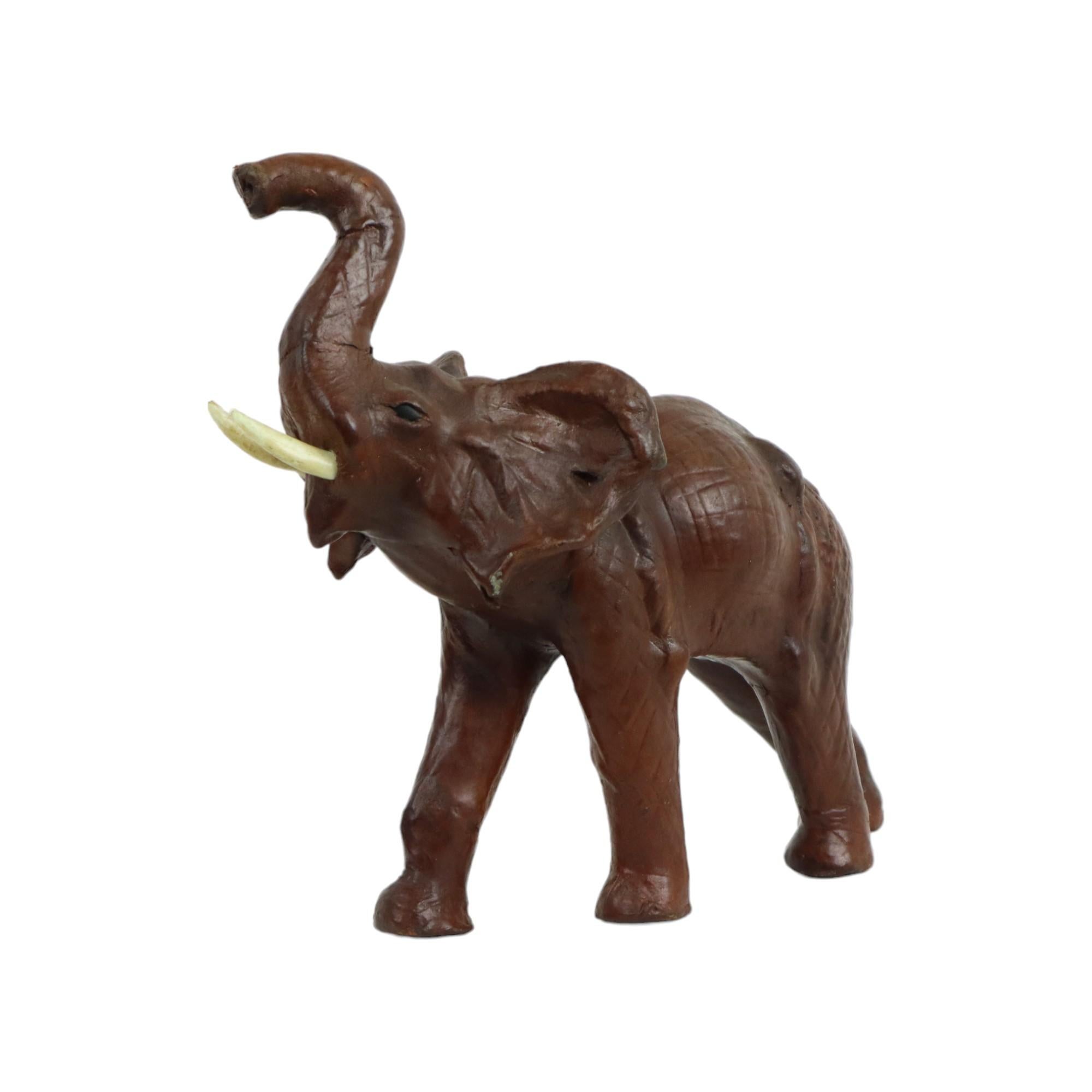Simpatica statua vintage di un elefante in cartapesta ricoperta di pelle marrone, con zanne in plastica, realizzata nella fabbrica di Liberty of London, circa anni '60.

In buone condizioni d'epoca, con leggeri segni d'uso e d'età conformi all'età,