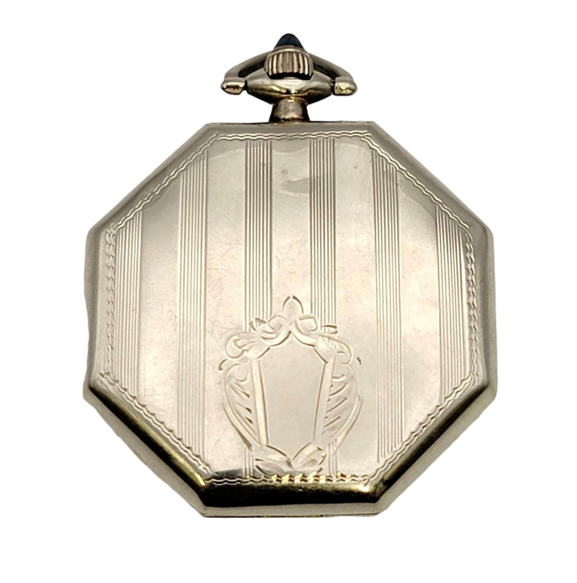 This stunning vintage 14 karat white gold pocket watch by Elgin is a stunning piece of history. The luxury solid gold timepiece is made with exquisite fine details. It features a 40mm octagonal case with a round white dial and black Arabic hour