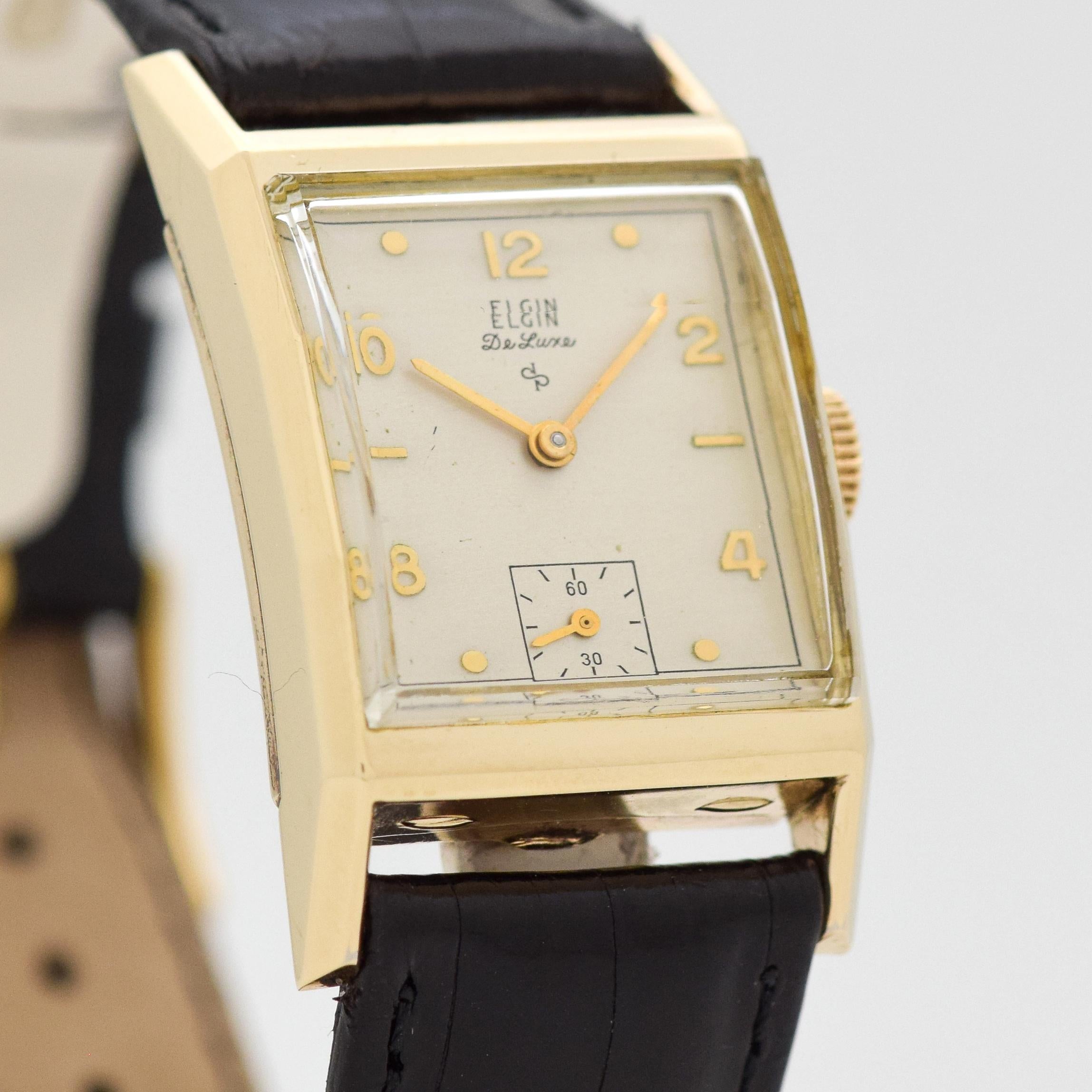 1948 Vintage De Luxe Square 10k Yellow Gold Filled watch with Beveled Crystal with Original Silver Dial with Applied Gold Color Arabic 2, 4, 8, 10, and 12 with Round Markers. 22mm x 36mm lug to lug (0.87 in. x 1.42 in.) - 17 jewel, manual caliber